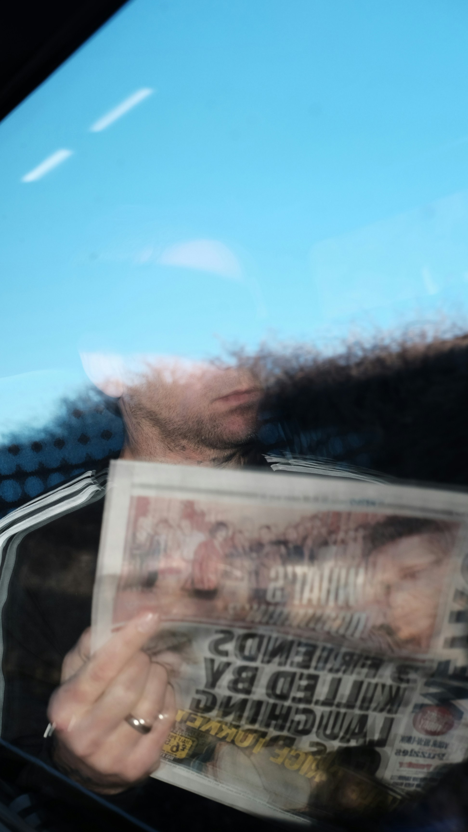 Man holding newspaper with headline about friends killed.