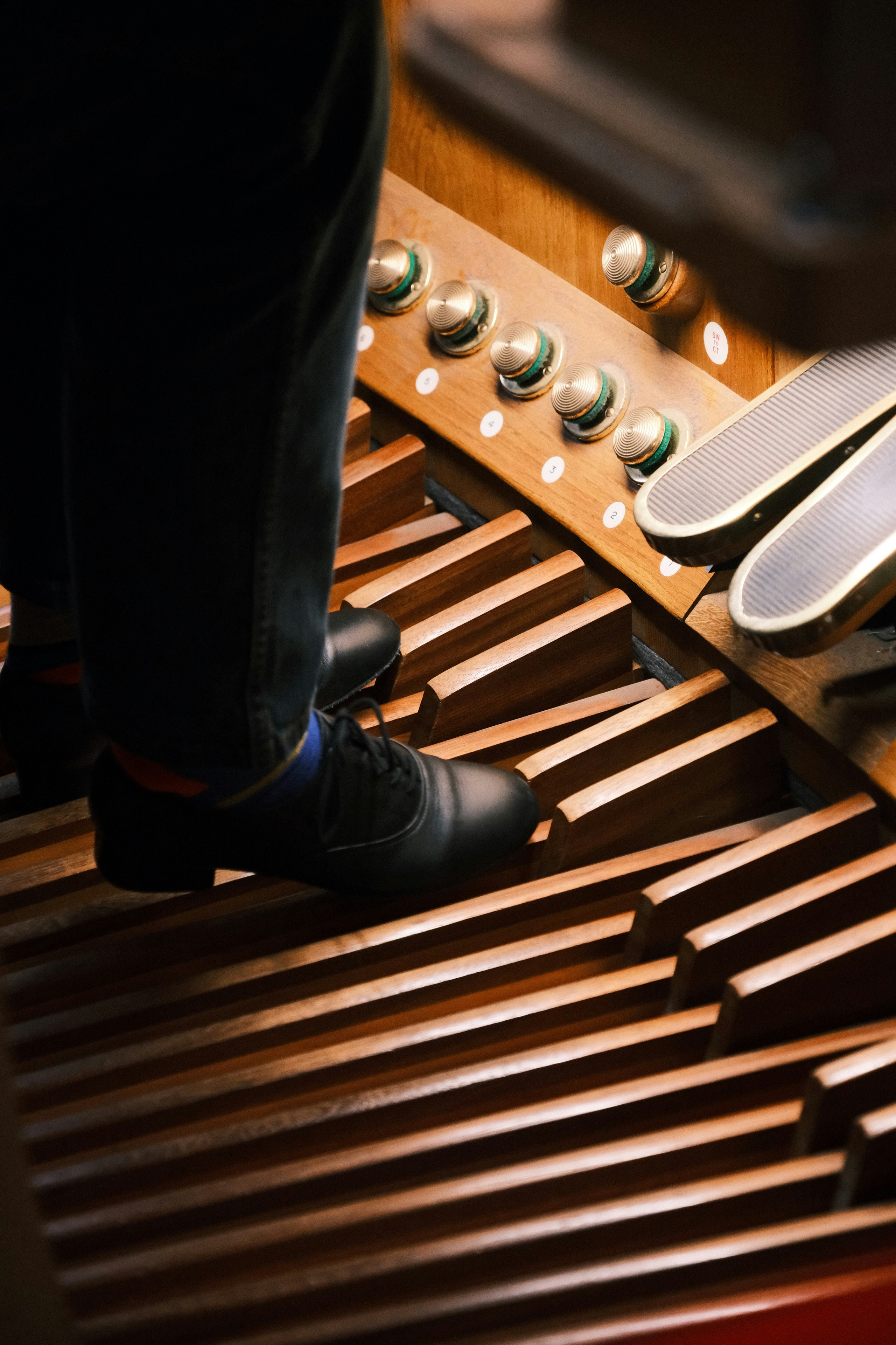 Person playing a pipe organ with feet
