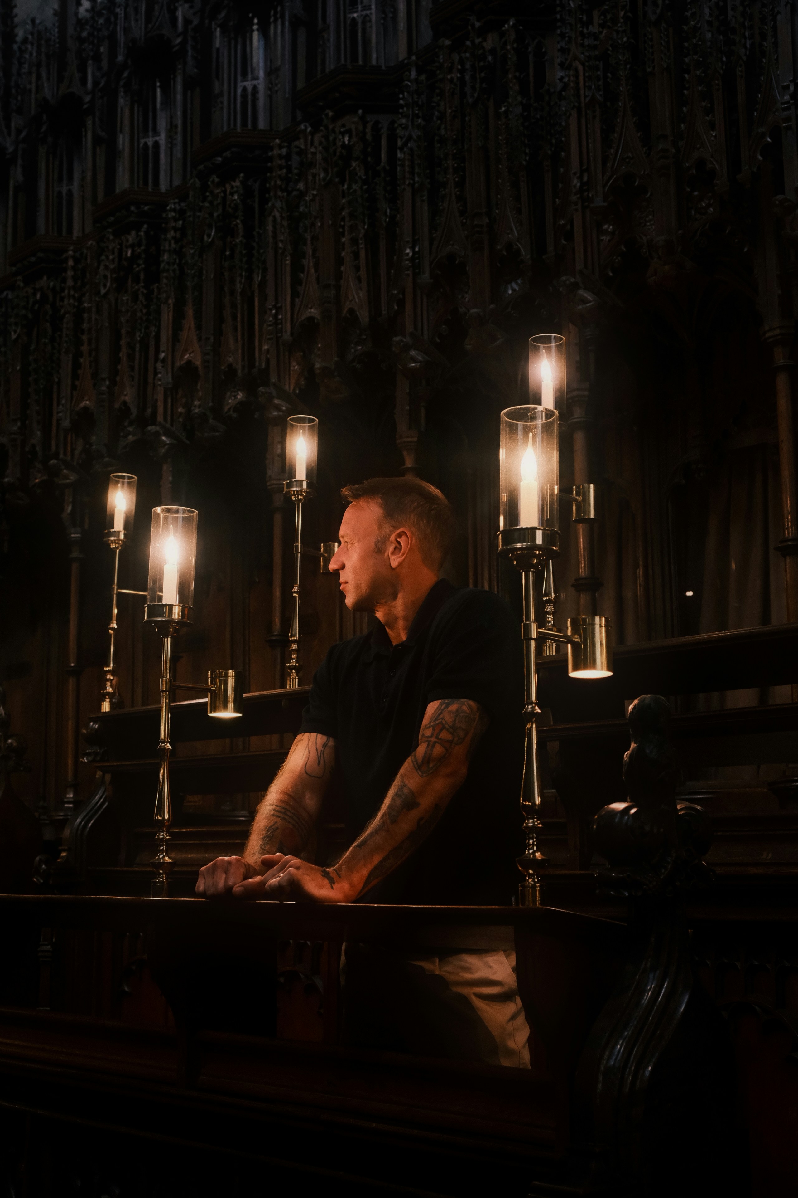 Man looking away in a dimly lit, ornate room.