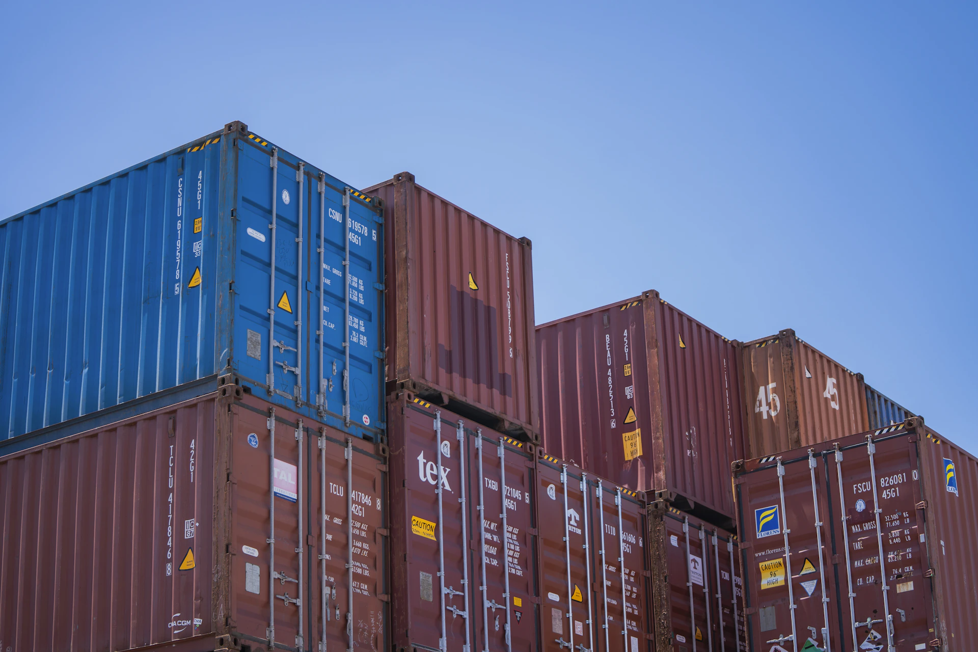 Stack of shipping containers against a blue sky