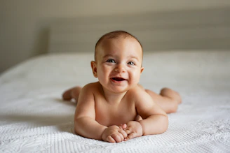 Smiling baby lying on a white textured surface