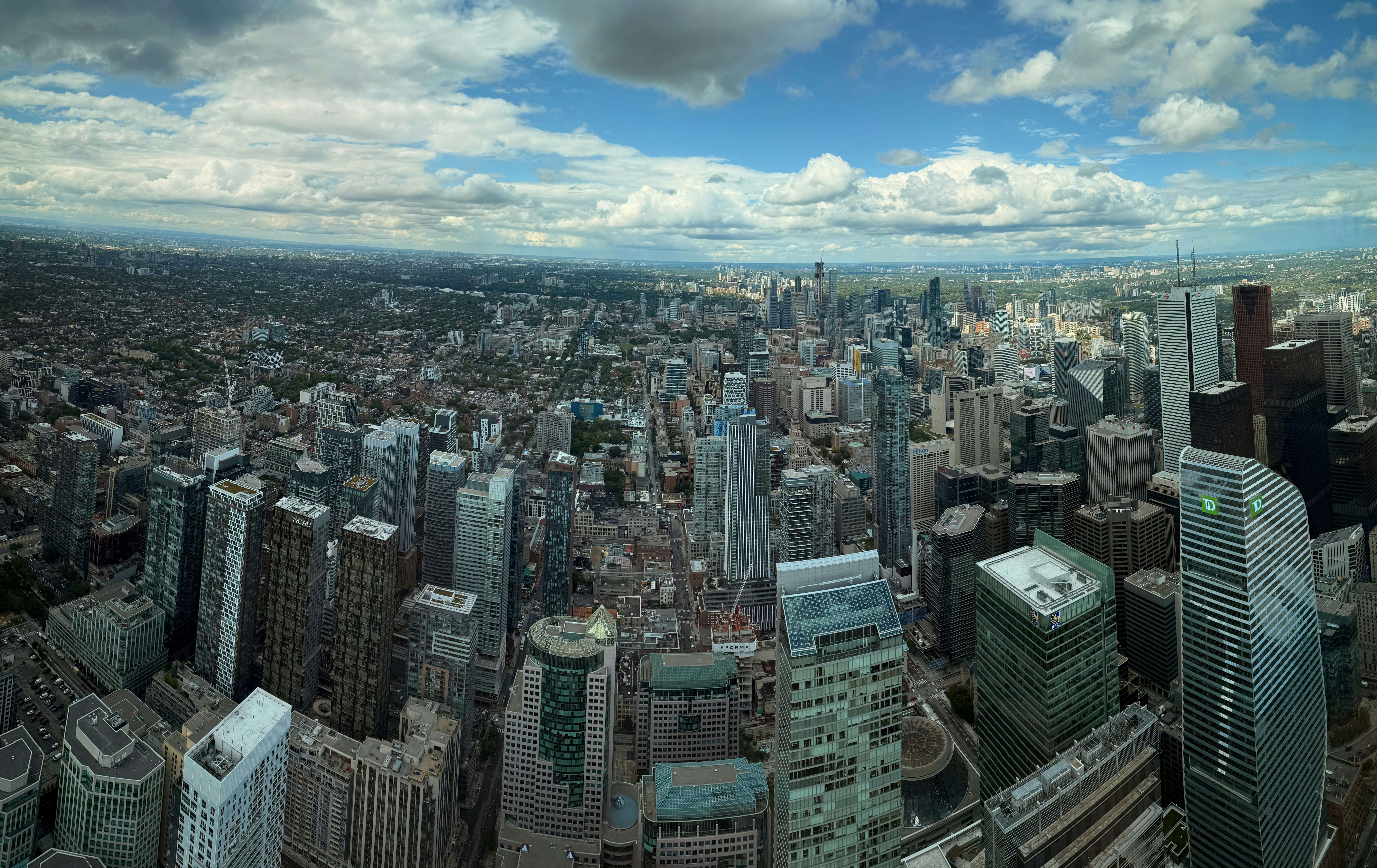 Expansive cityscape with numerous tall buildings under clouds.