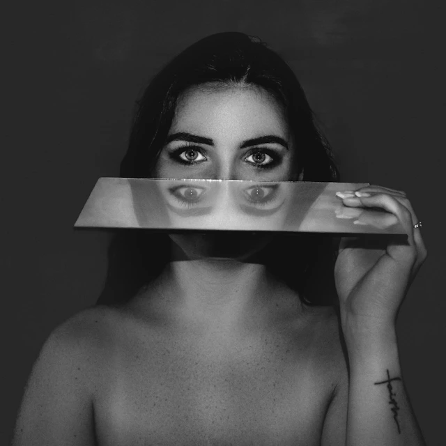 femme qui tient un miroir pour illustrer l'article sur la culpabilité