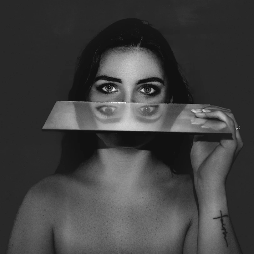 femme qui tient un miroir pour illustrer l'article sur la culpabilité