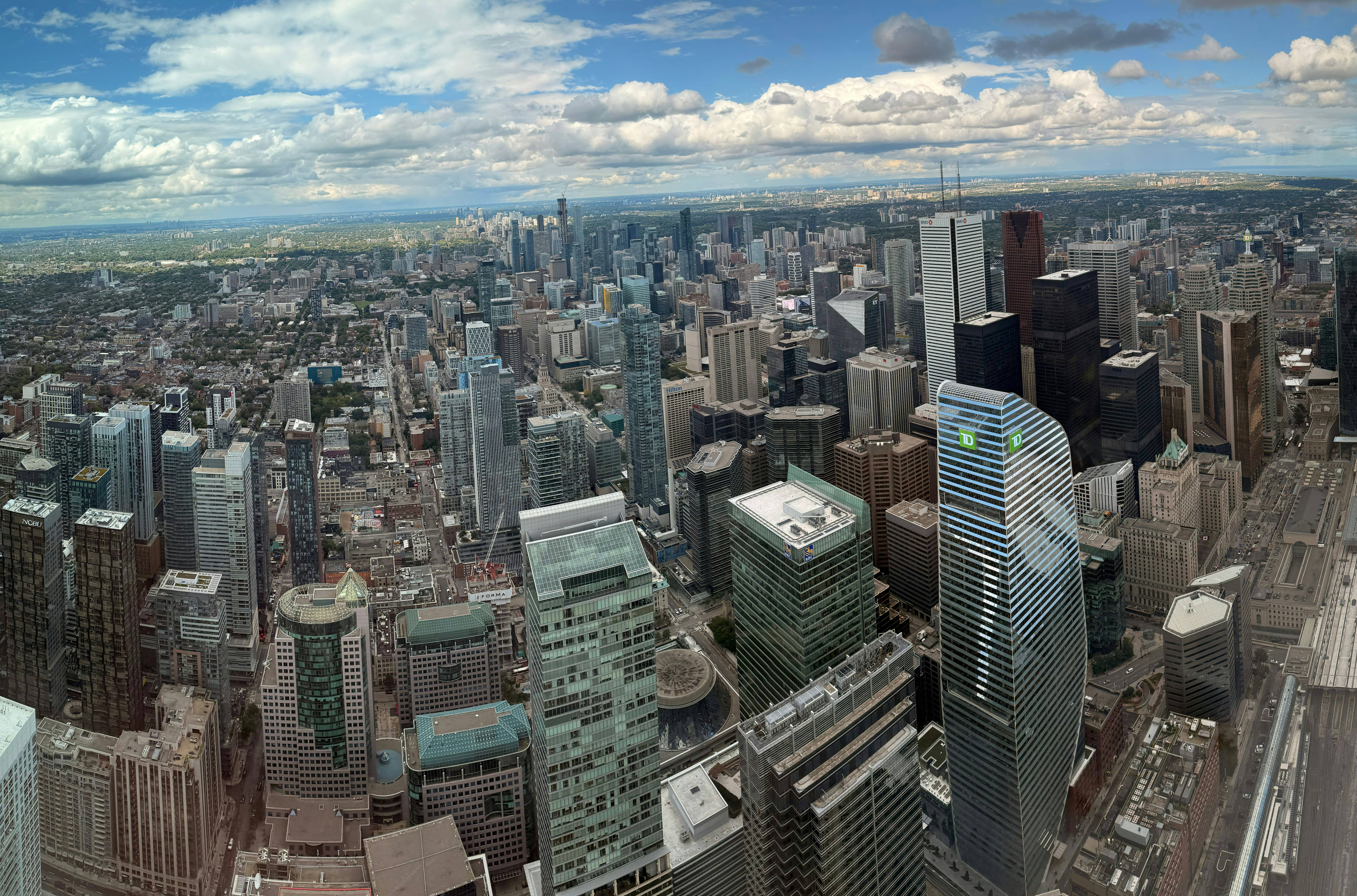 Expansive cityscape with numerous tall buildings under a cloudy sky.