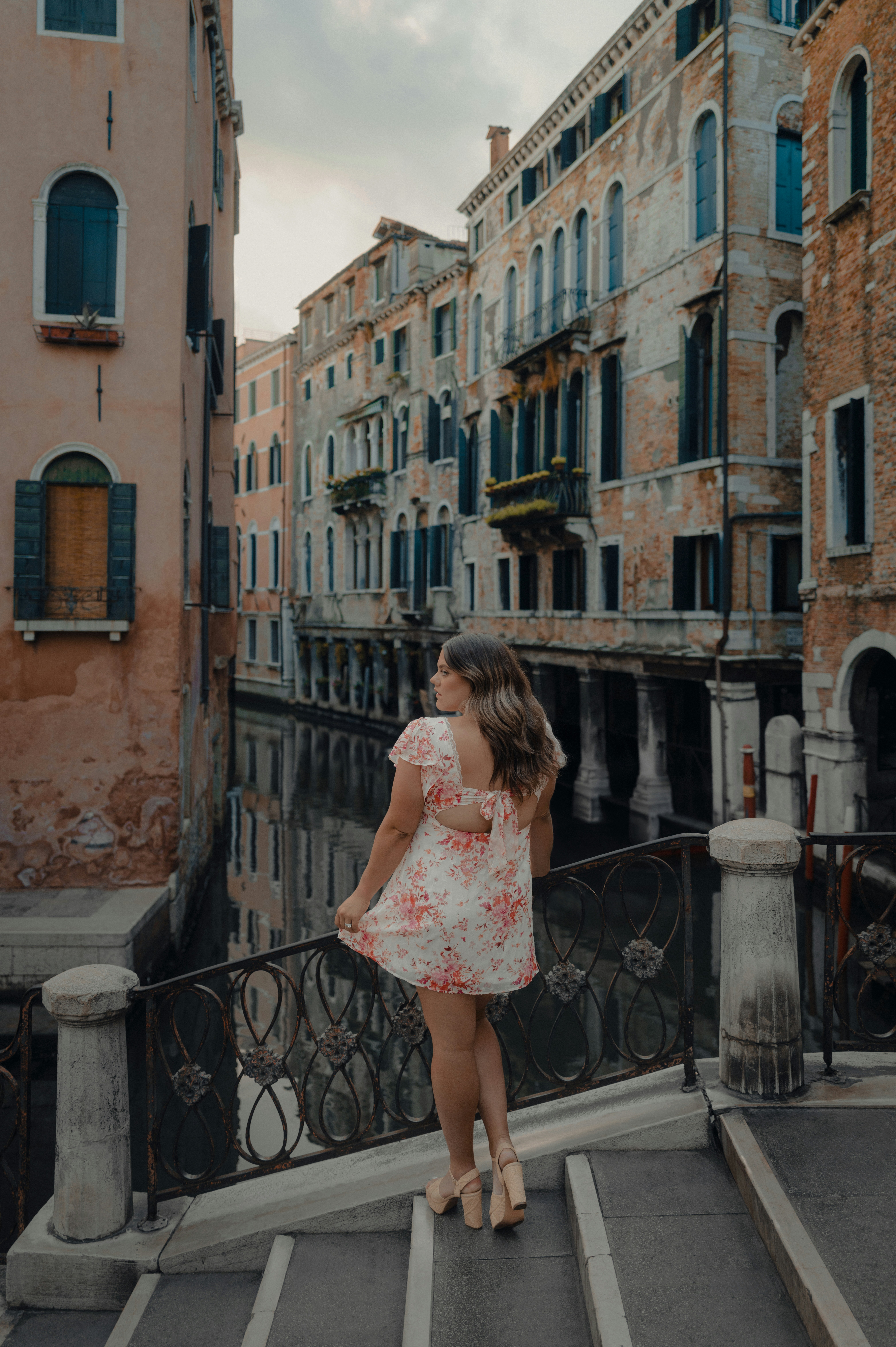 Woman on bridge overlooking venetian canal
