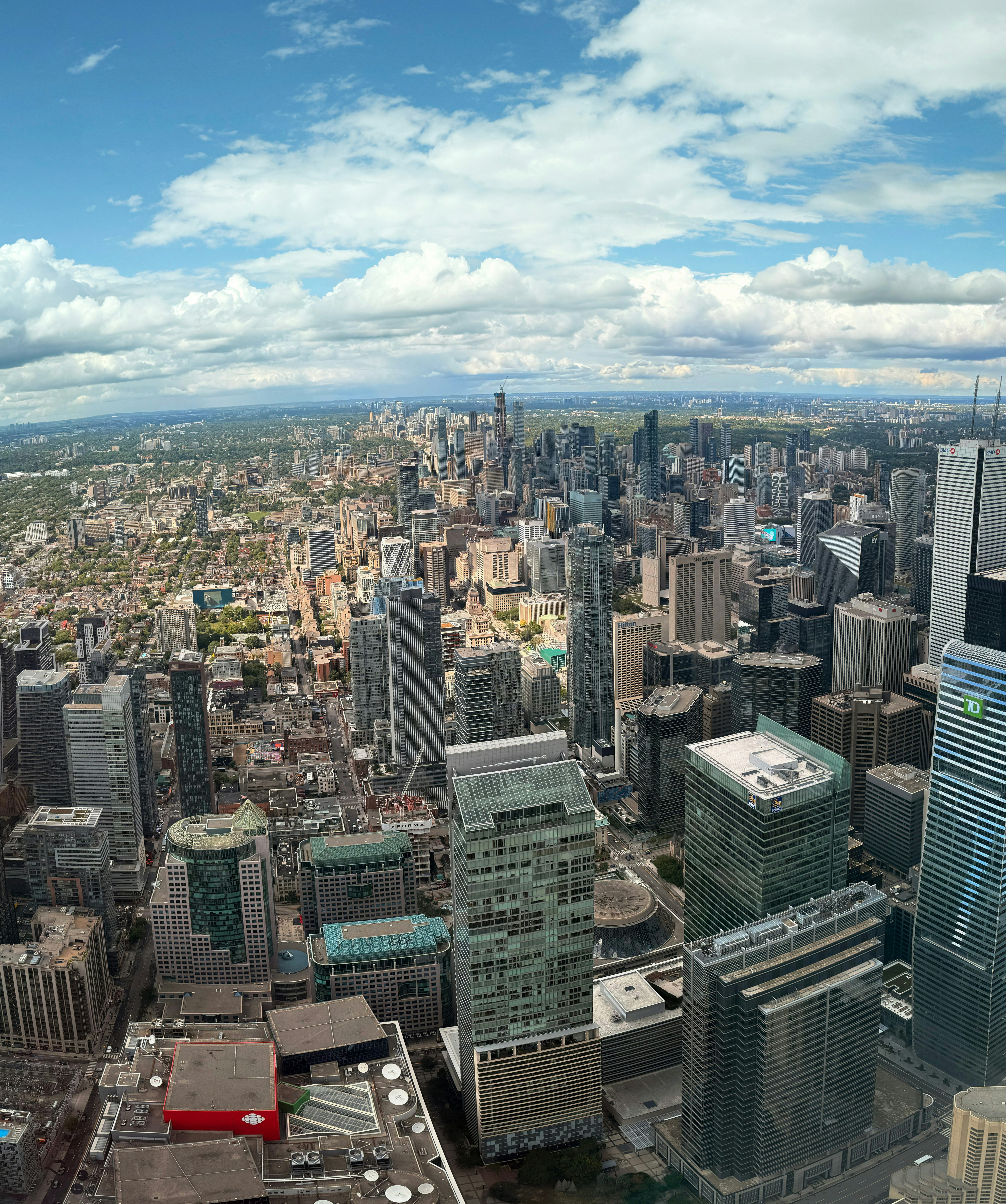 Panoramic view of a sprawling city skyline under clouds.