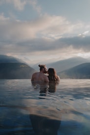 Couple kissing in a serene mountain lake at sunset