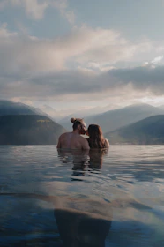 Couple kissing in a serene mountain lake at sunset