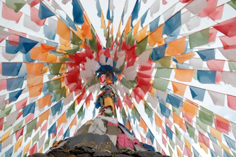 Colorful prayer flags strung around a stupa