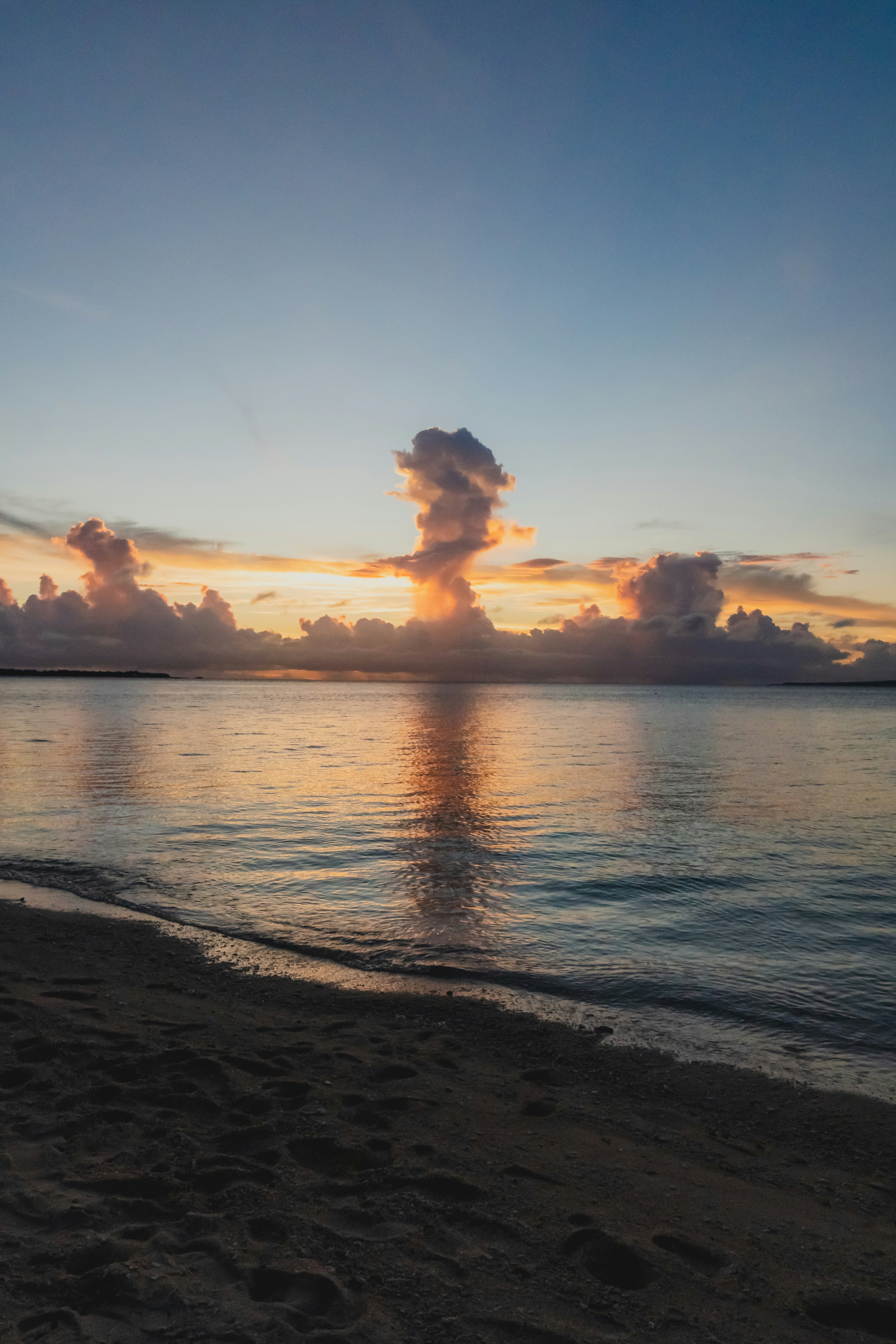 Sunset over calm ocean with dramatic clouds