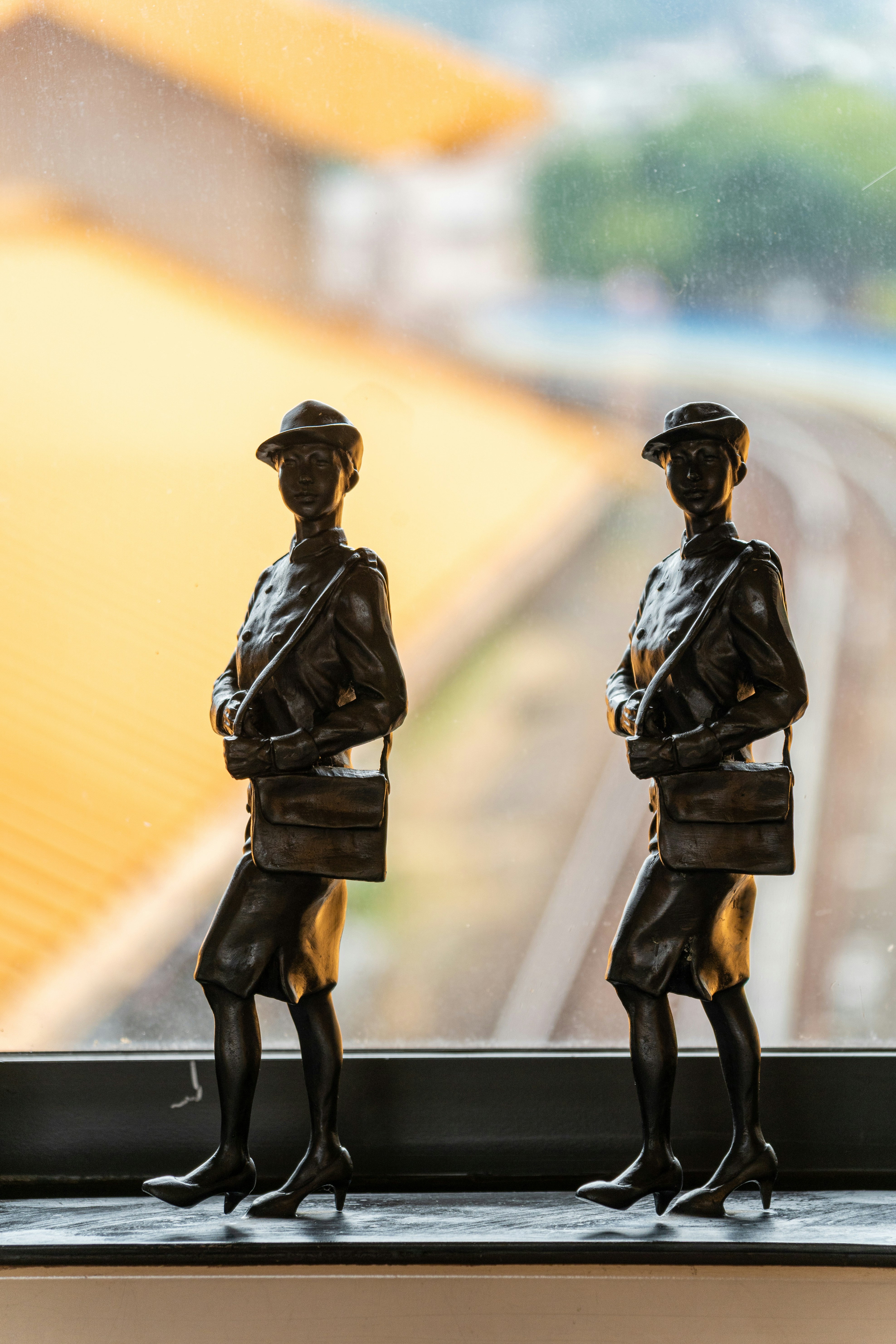 Two bronze statues of women with bags.