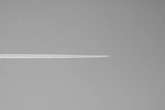 Airplane contrail across a clear sky