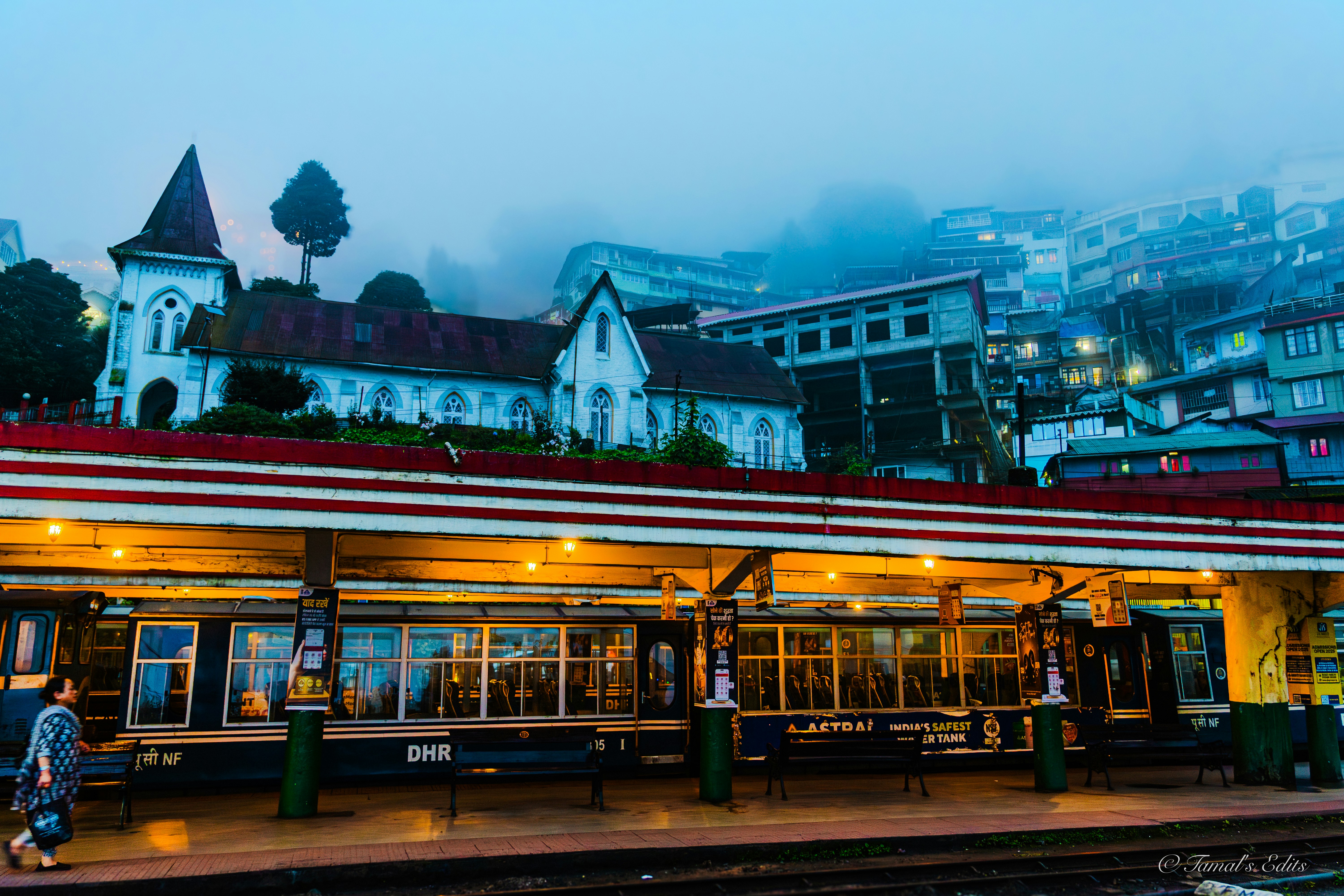 Train station with a church on the hill.