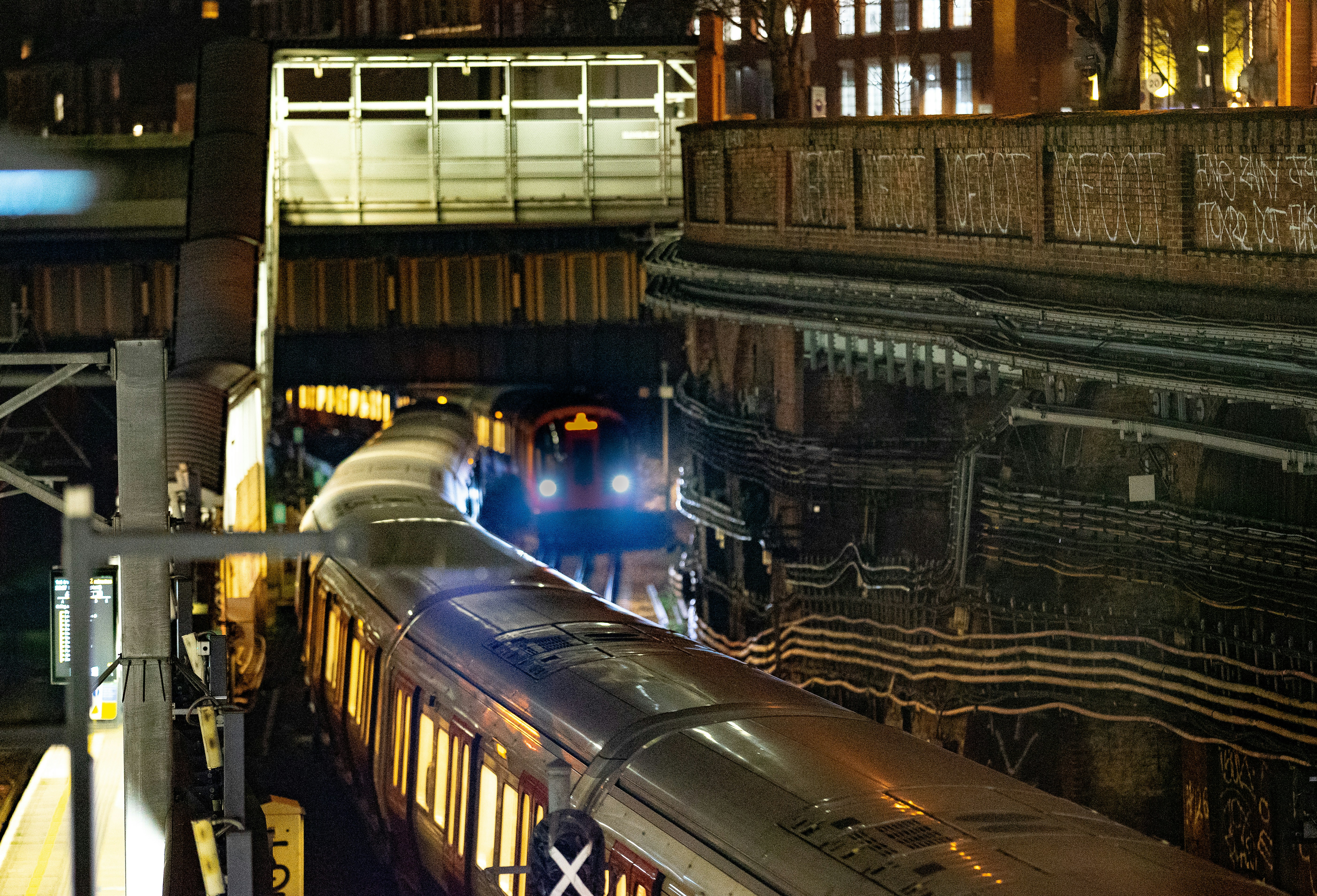 Two trains at a station at night