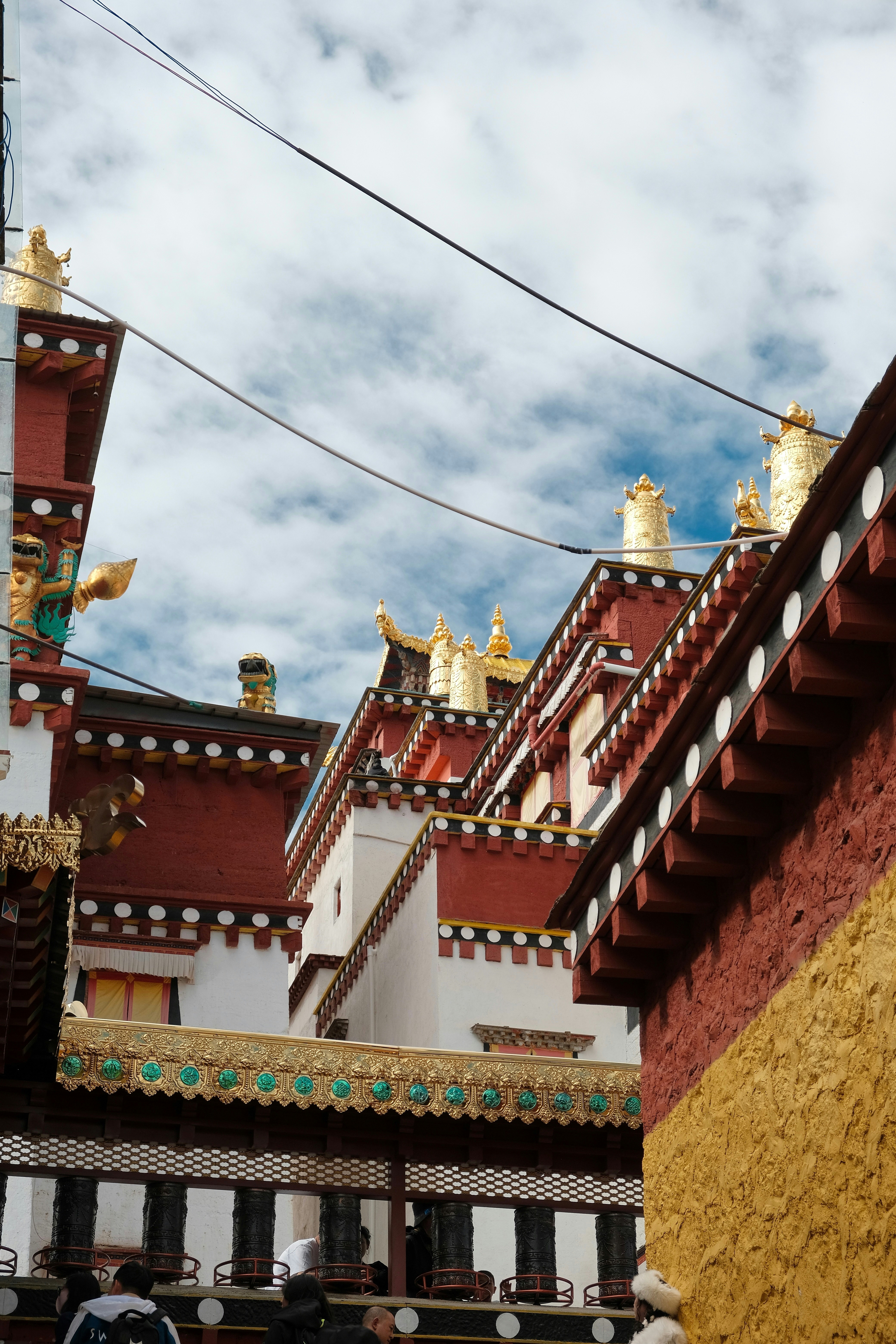 Ornate tibetan monastery rooftops under a cloudy sky