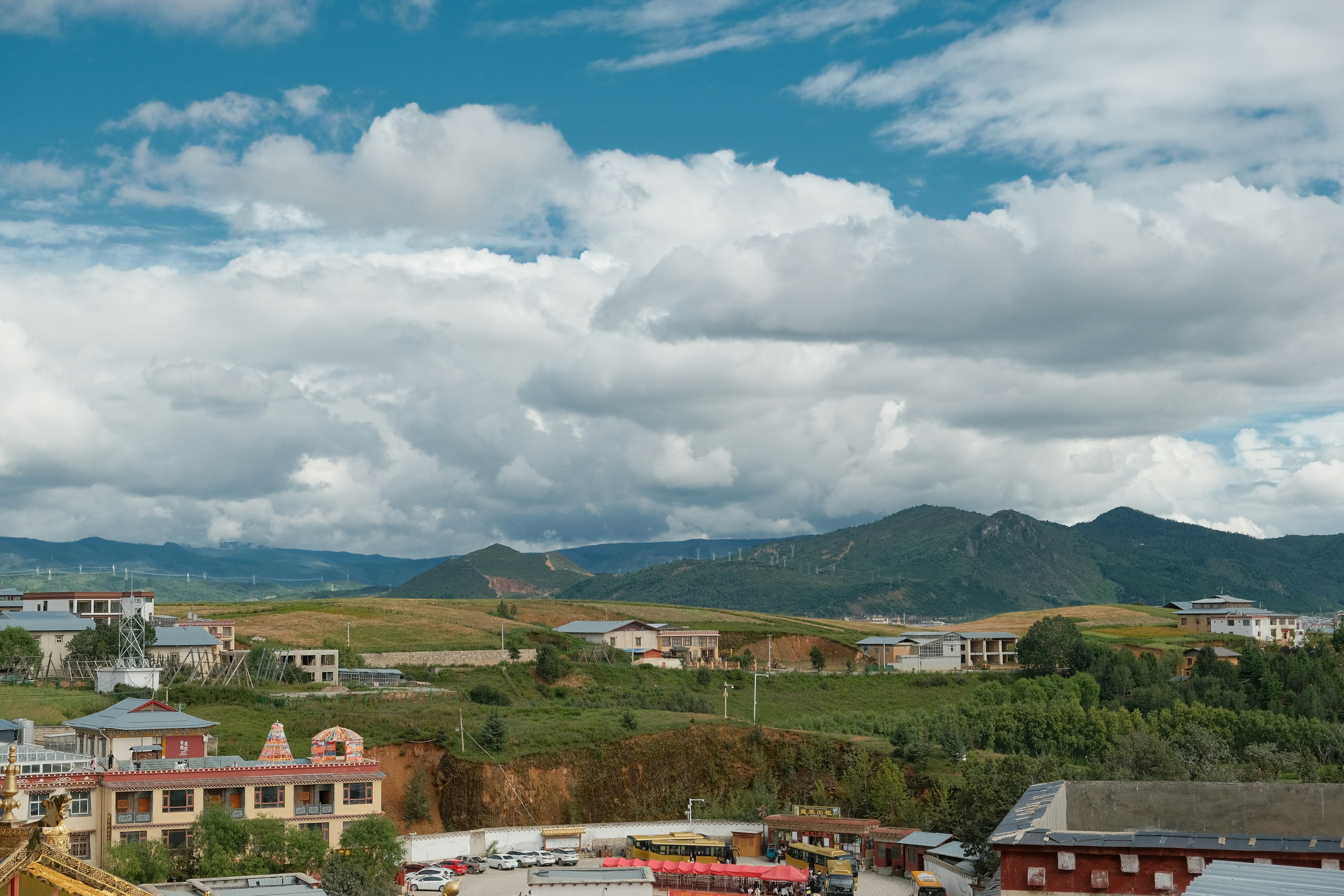 Town nestled in a valley beneath rolling hills.