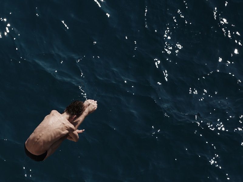 accomplished athlete diving into crystal blue water