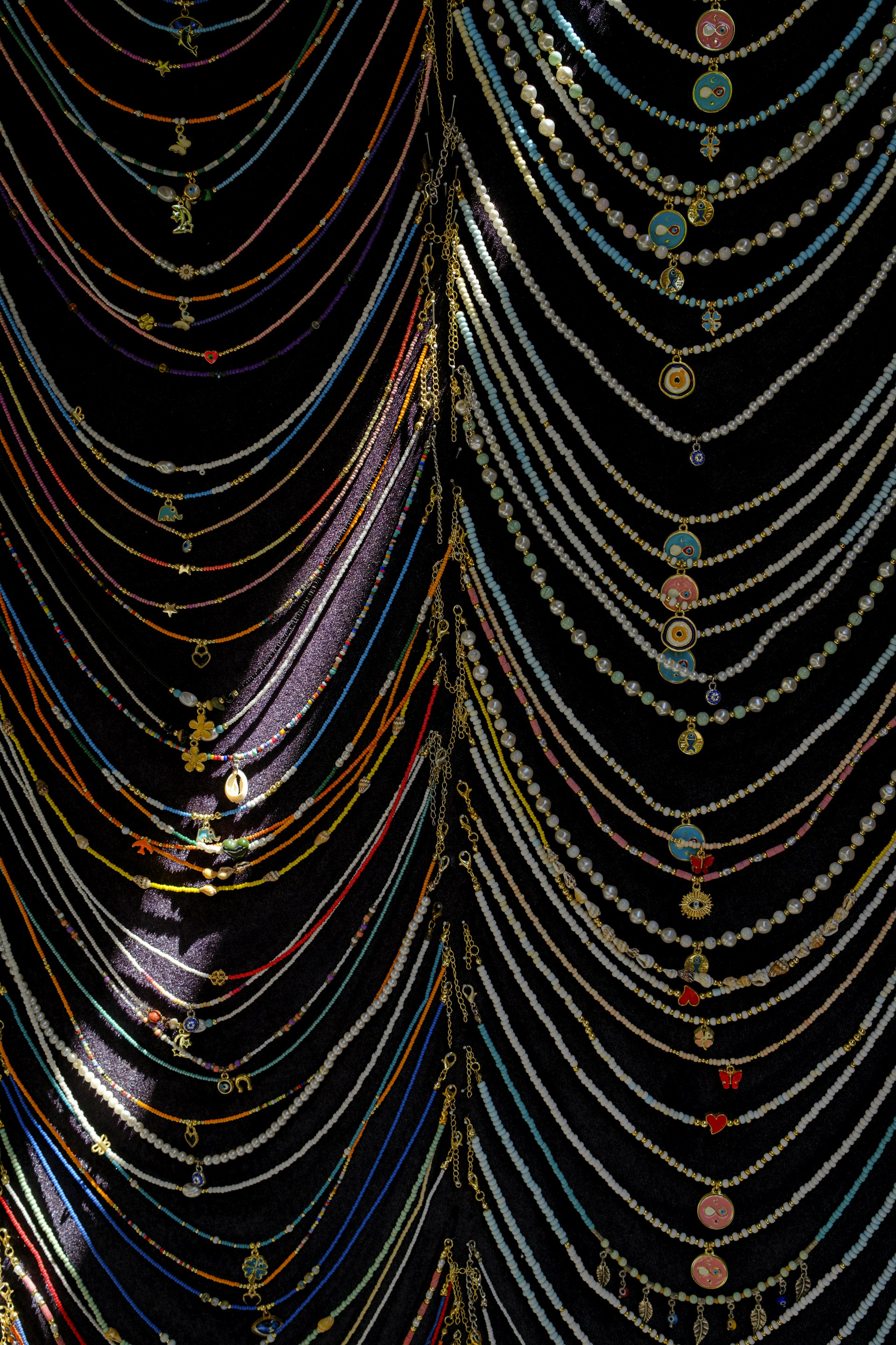 Colorful beaded necklaces displayed on a dark background