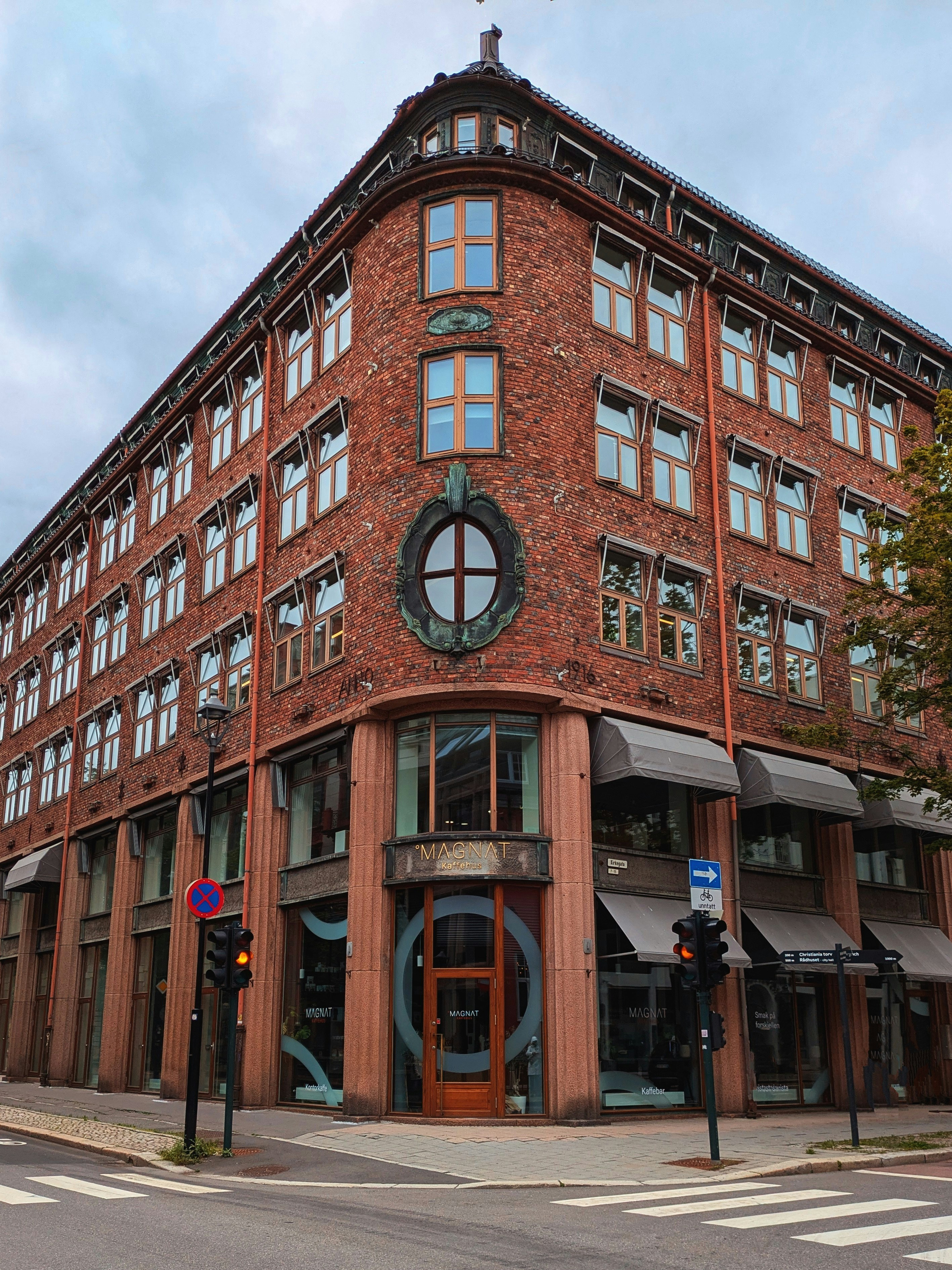 Corner building with red brick facade and many windows.