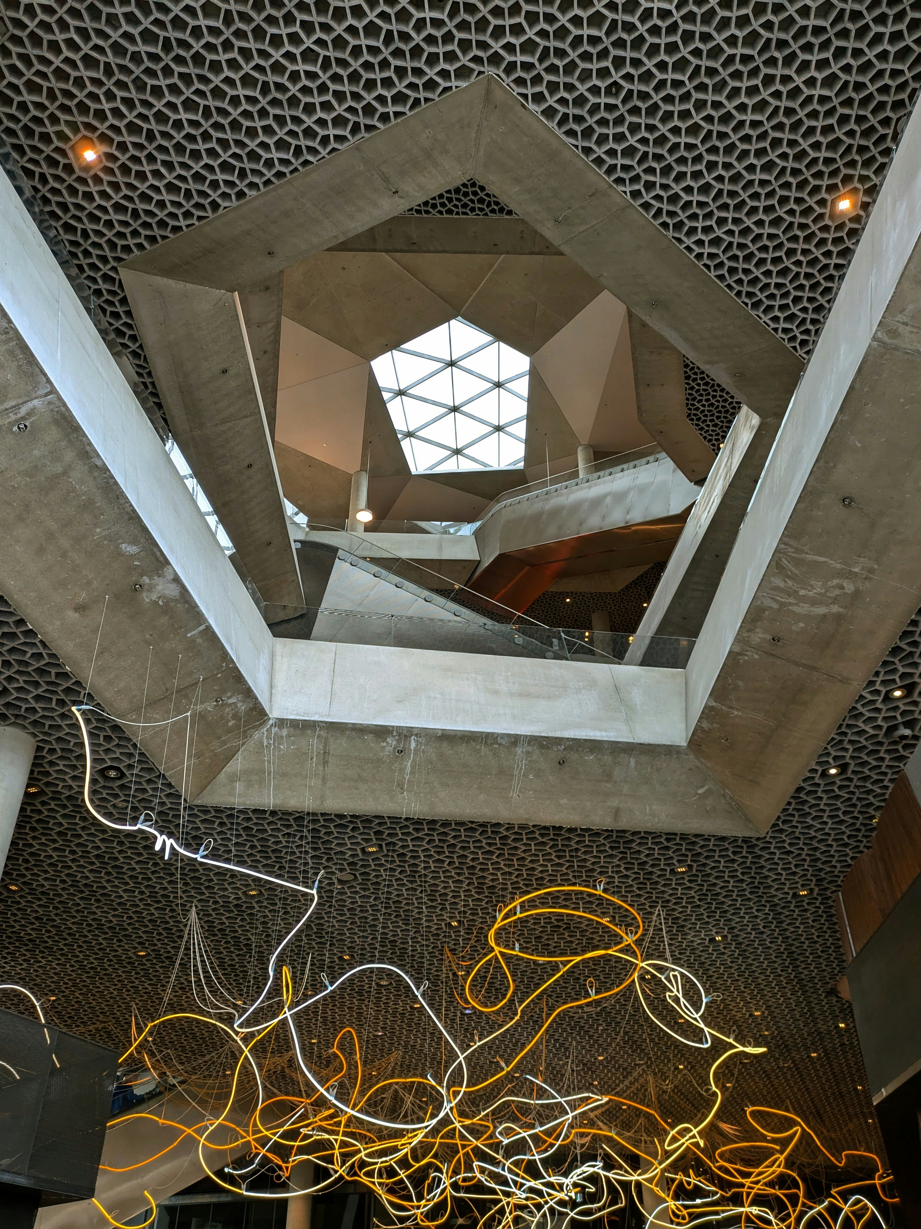 Modern interior with geometric concrete architecture and sculpture.