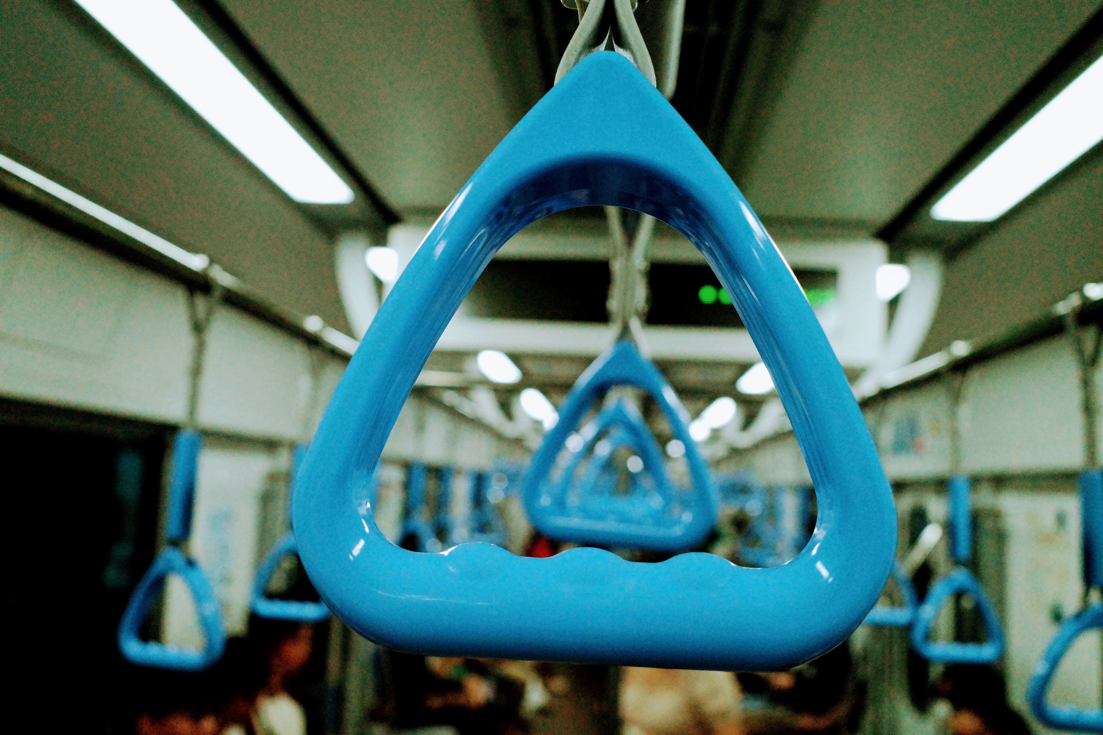 Blue grab handles inside a public transport vehicle.