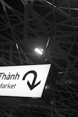 Market sign with directional arrow under metal structure