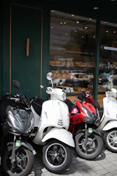 Several parked scooters in front of a shop.