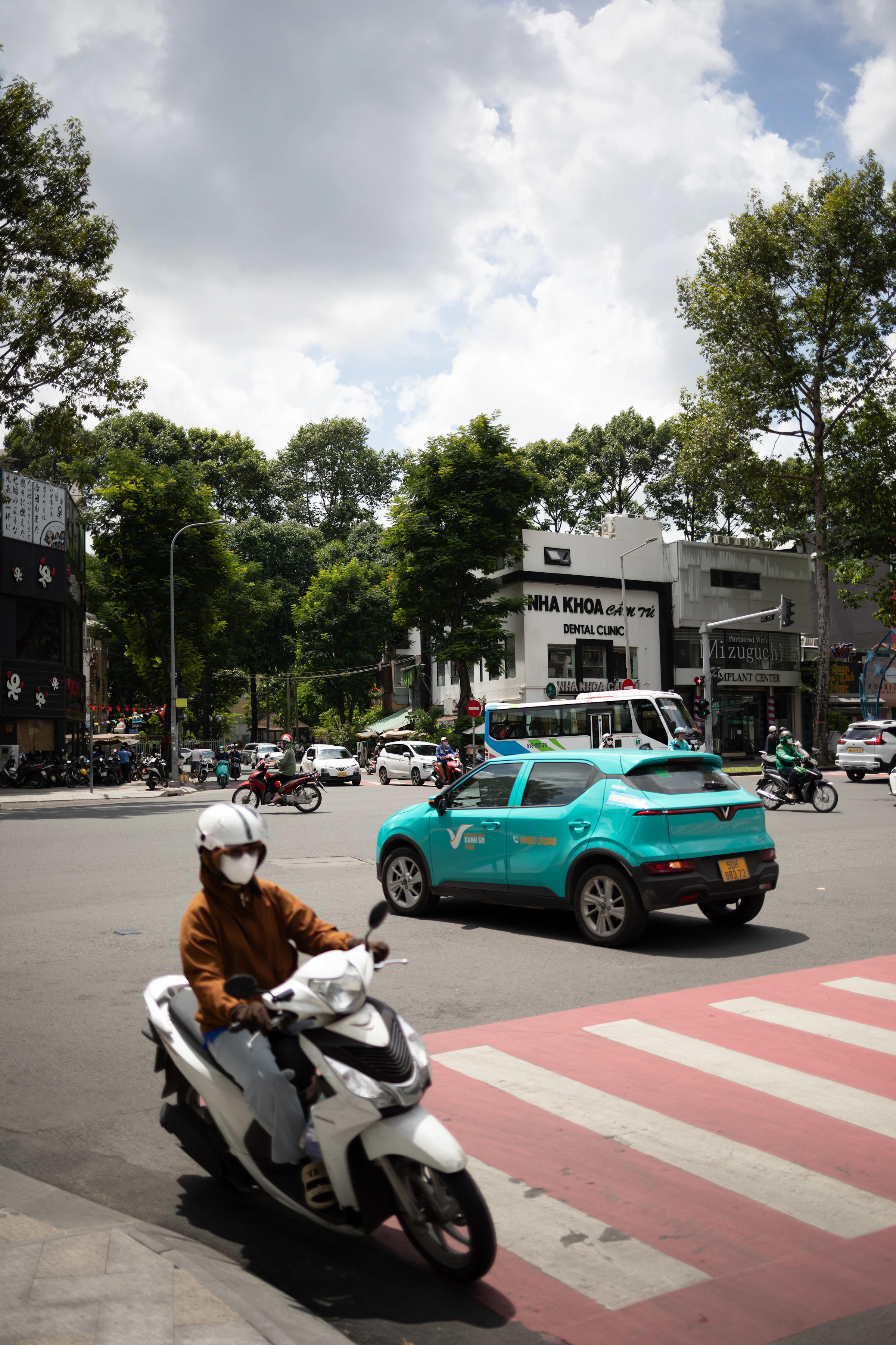 Carrefour urbain, scooter entre voitures et camion