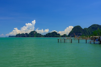 Turquoise ocean water with islands and a pier.