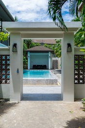 Entrance to a resort pool area with lounge chairs
