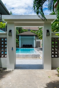 Entrance to a resort pool area with lounge chairs