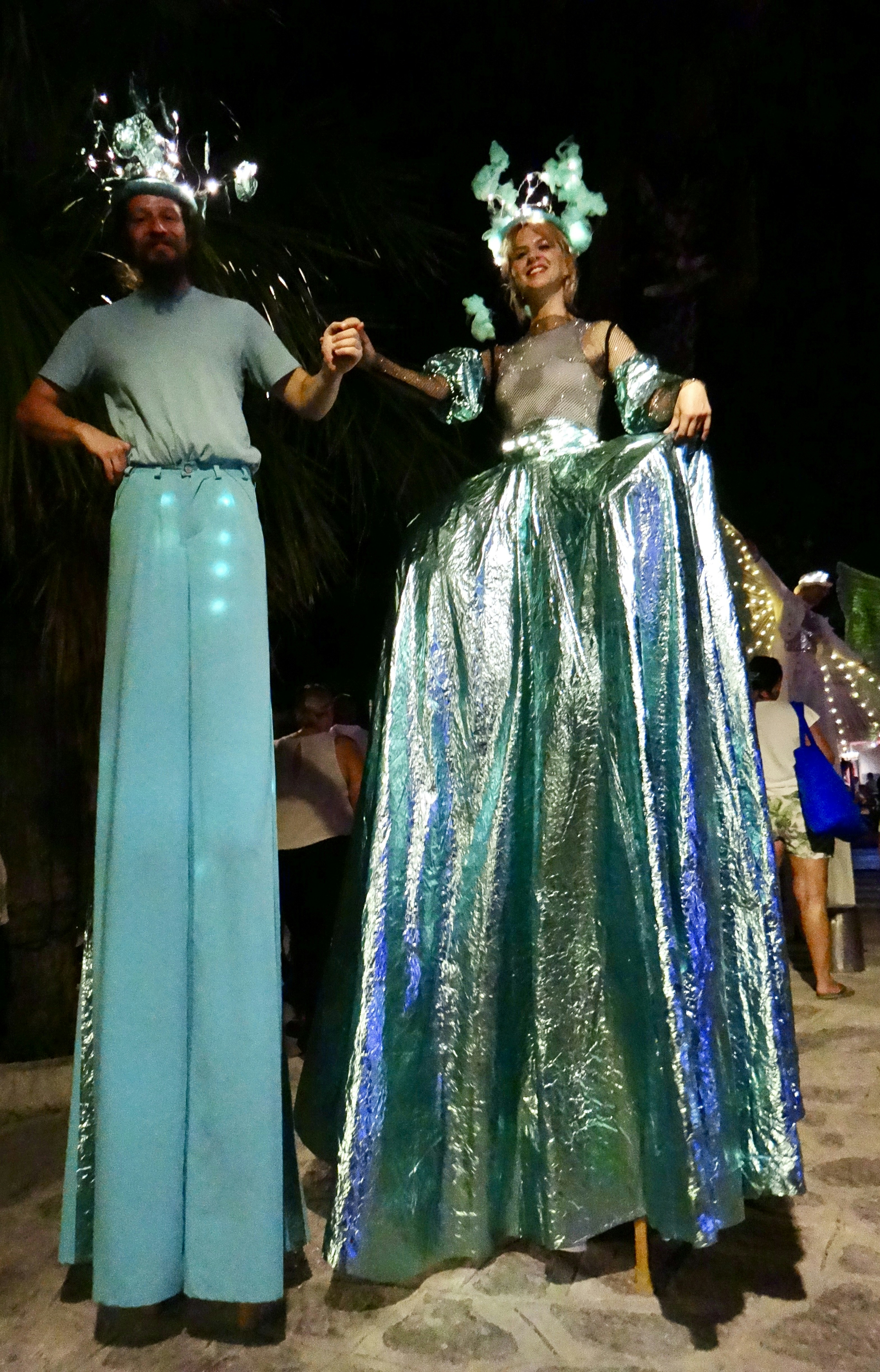 illuminated stilt walkers at night