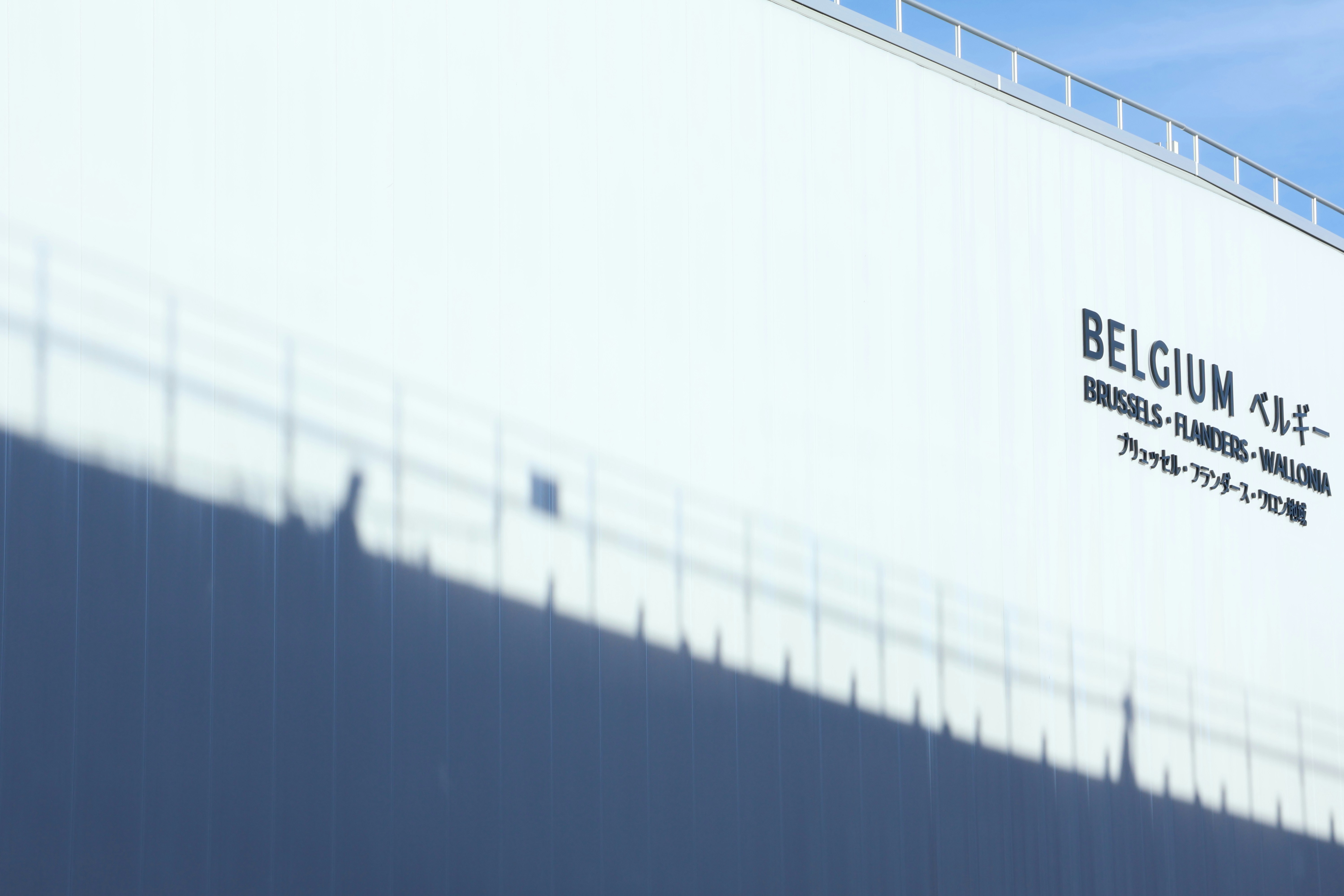 Modern white building with shadows and text.