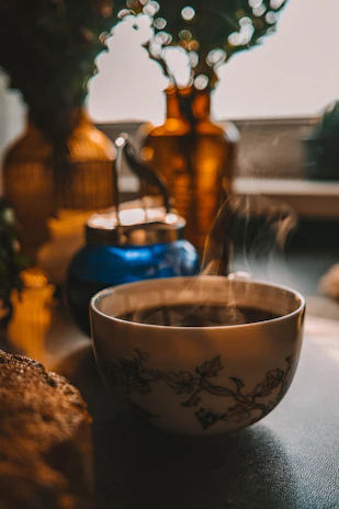 Steaming cup of coffee with decorative vases