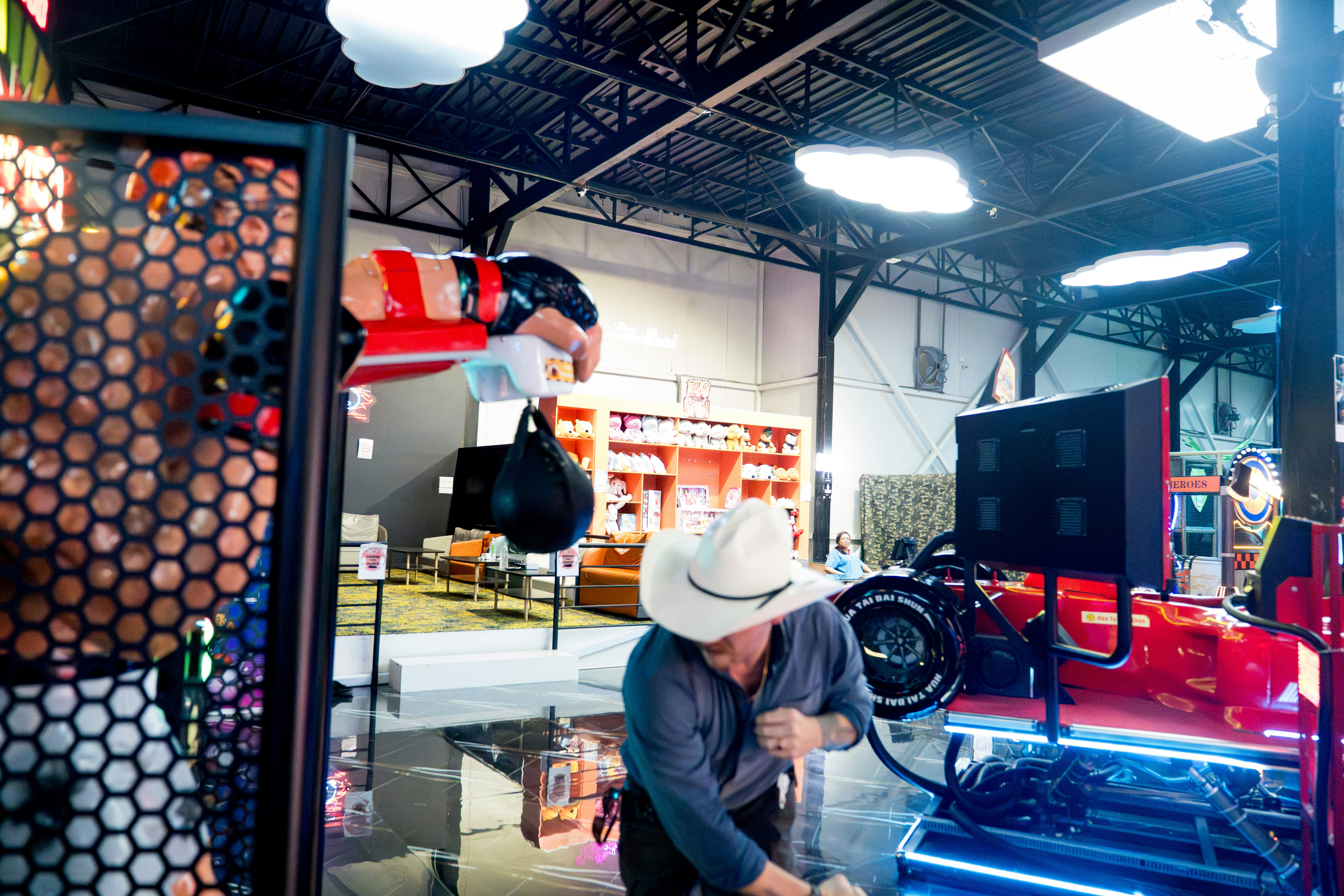 AI automation replacing workers technology - Man in cowboy hat works on arcade game