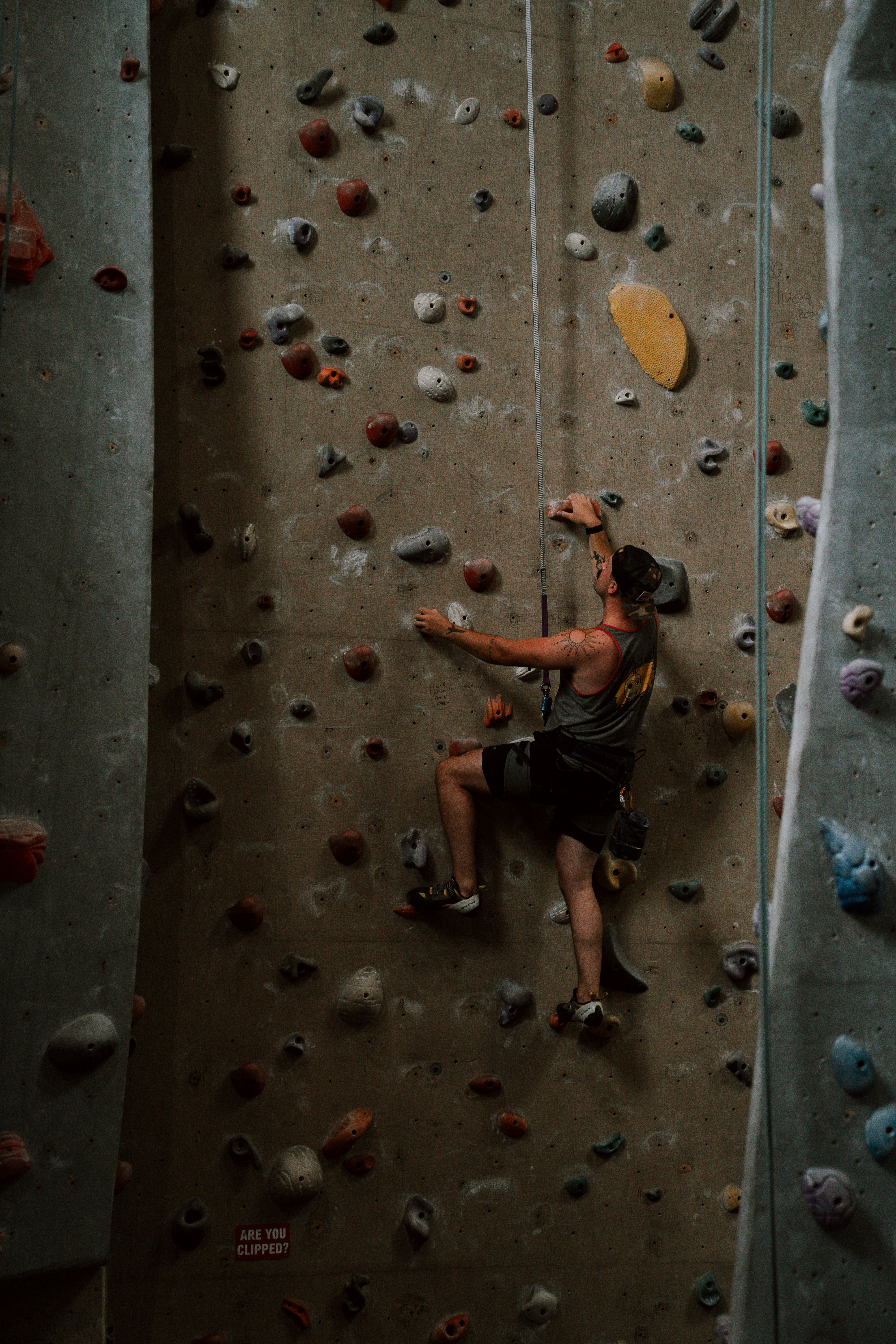 Man climbing a rock wall with safety rope