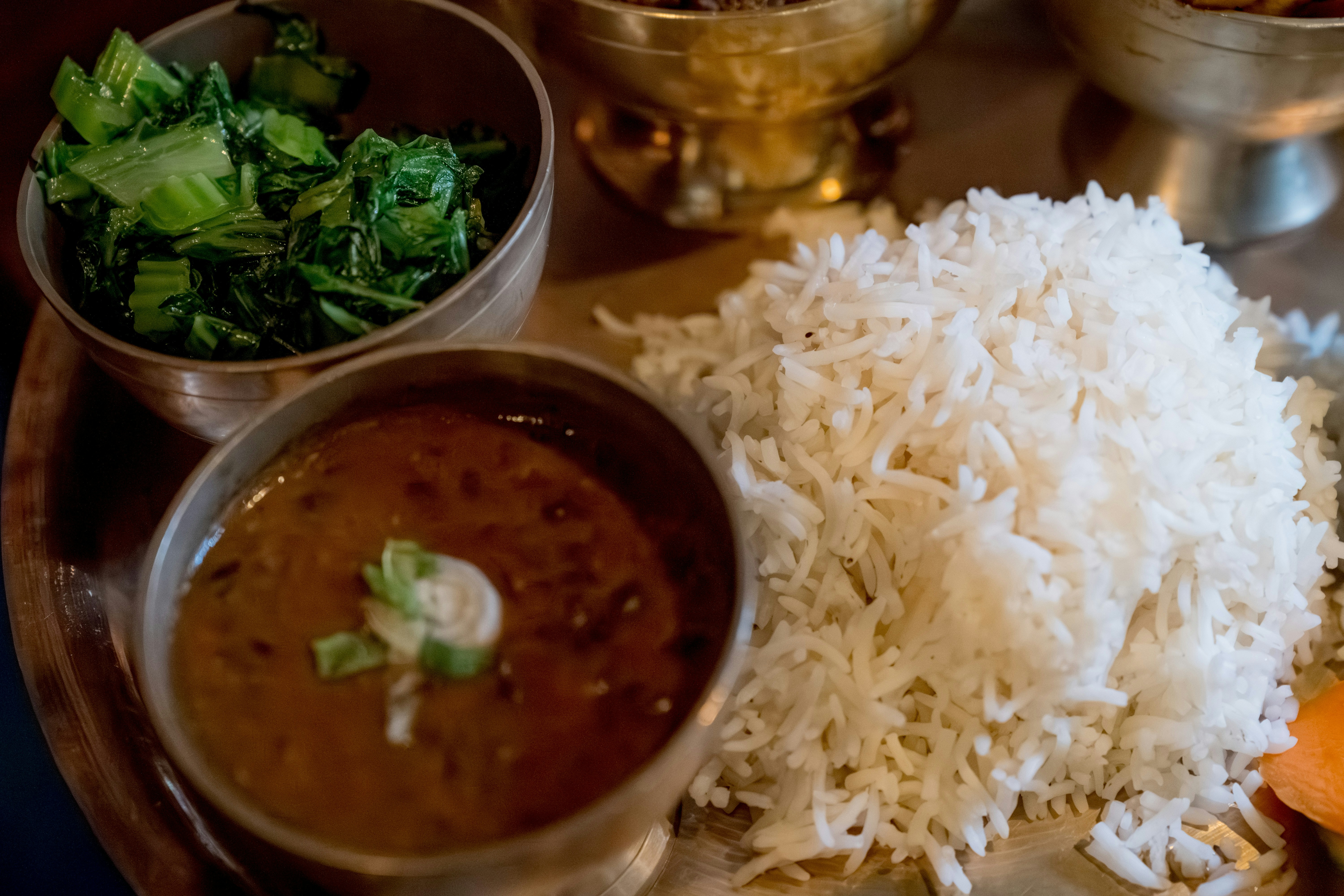 A vibrant and balanced Indian thali with different small bowls containing lentils, vegetables, rice, roti, and salad.