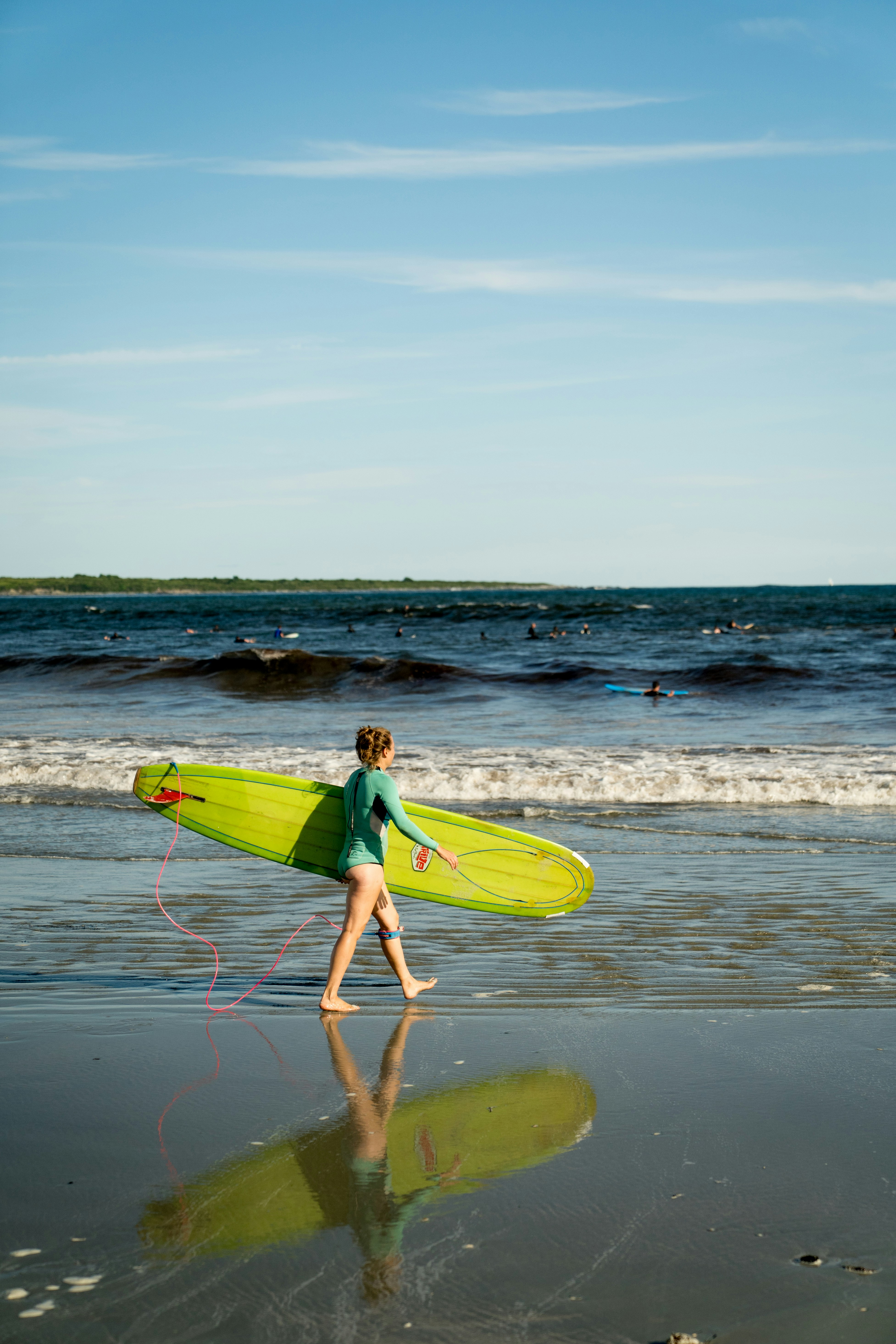 Young surfer walks on beach with surfboard
