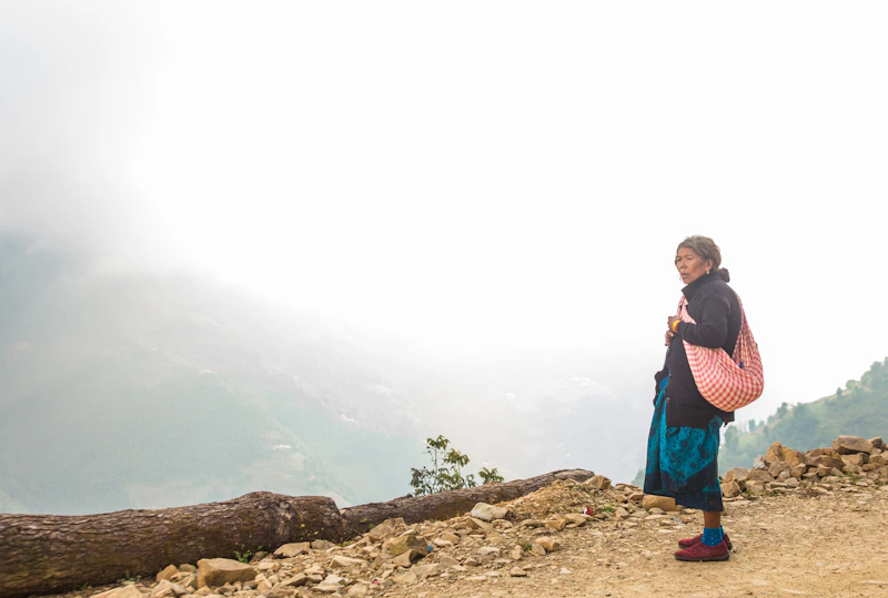 Mujer madura con bolso rosa en paisaje montañoso