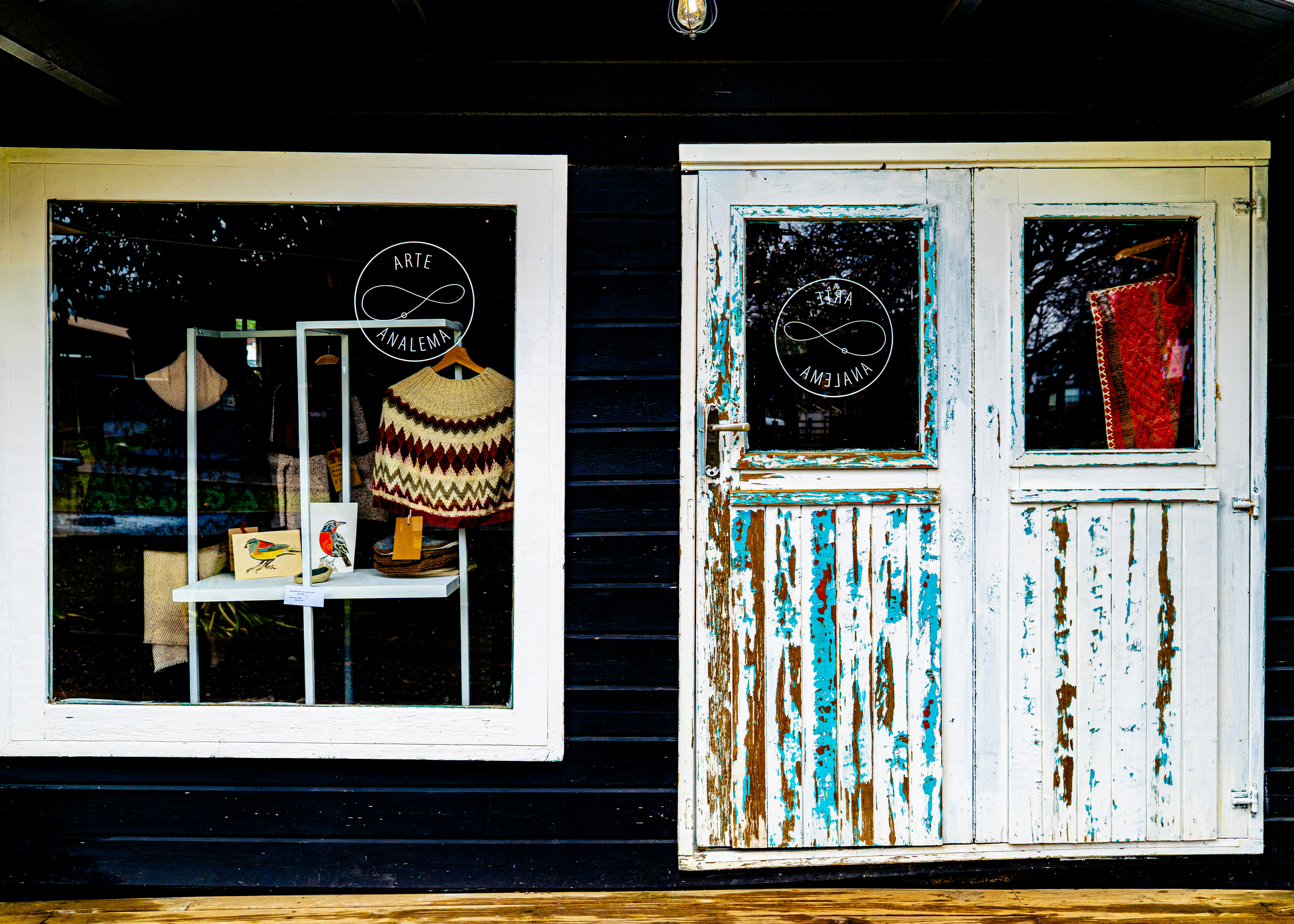 Rustic shop facade with a window and distressed doors.