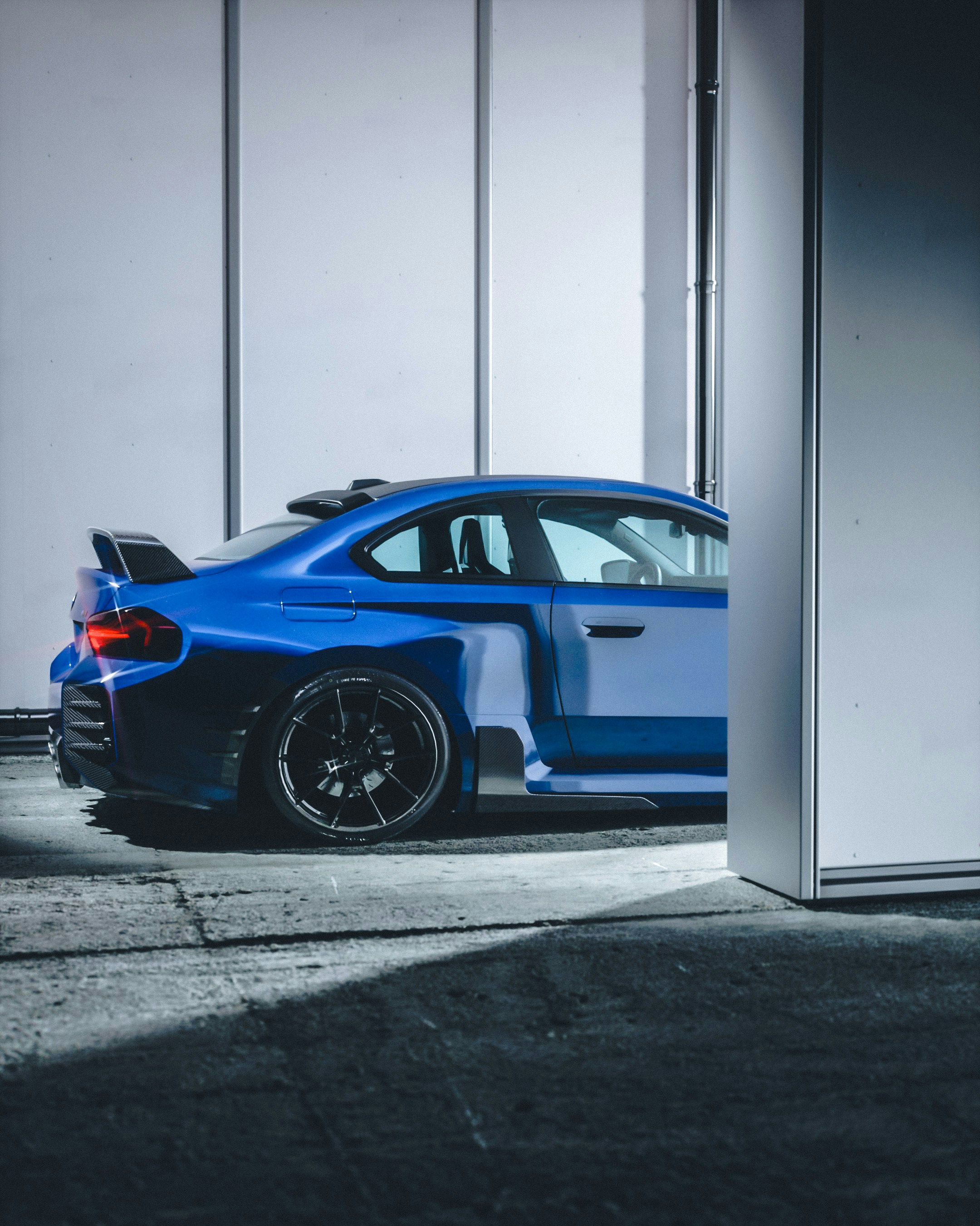 Um carro esportivo azul personalizado com um grande spoiler.