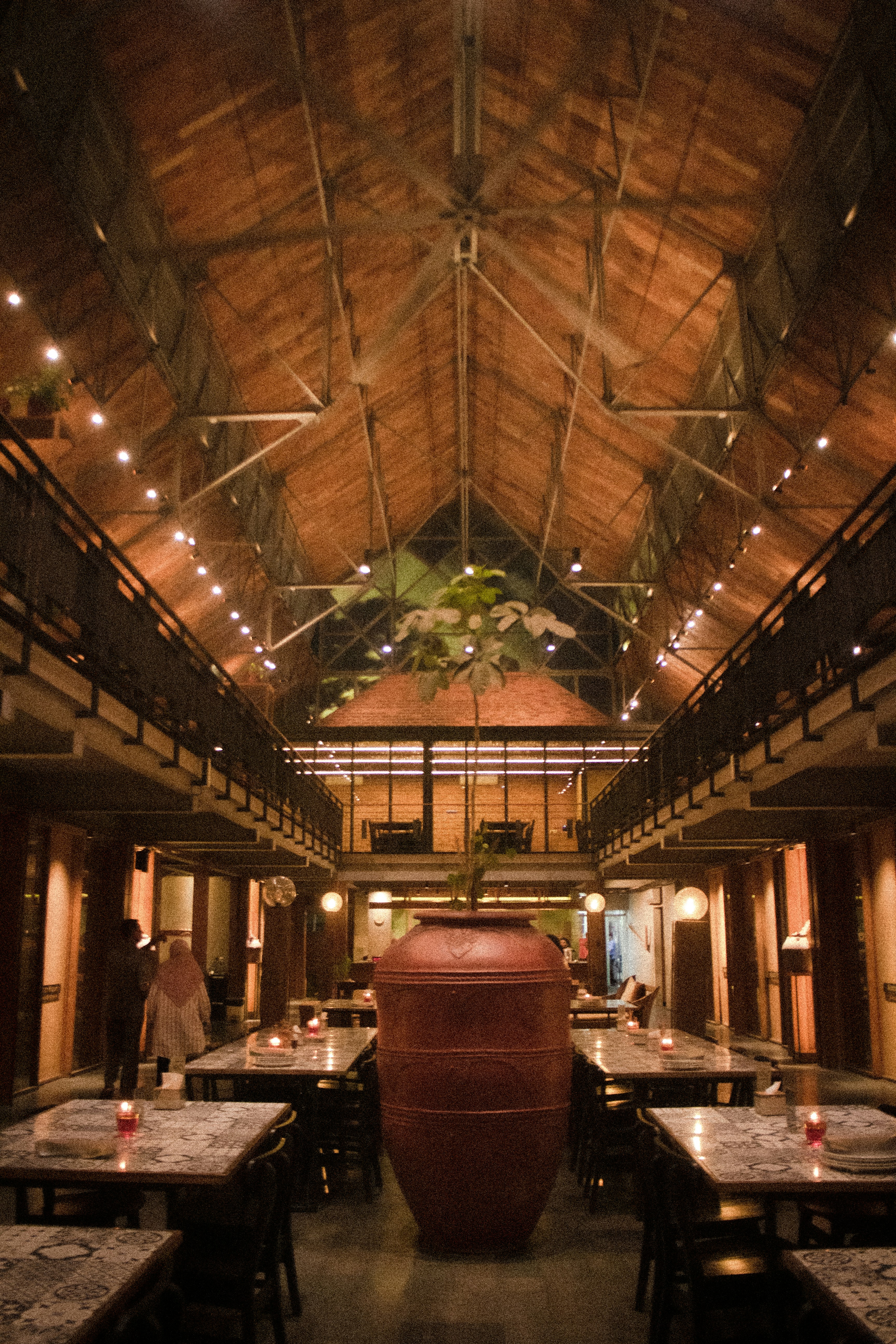 Rustic restaurant interior with wooden beams and tables.