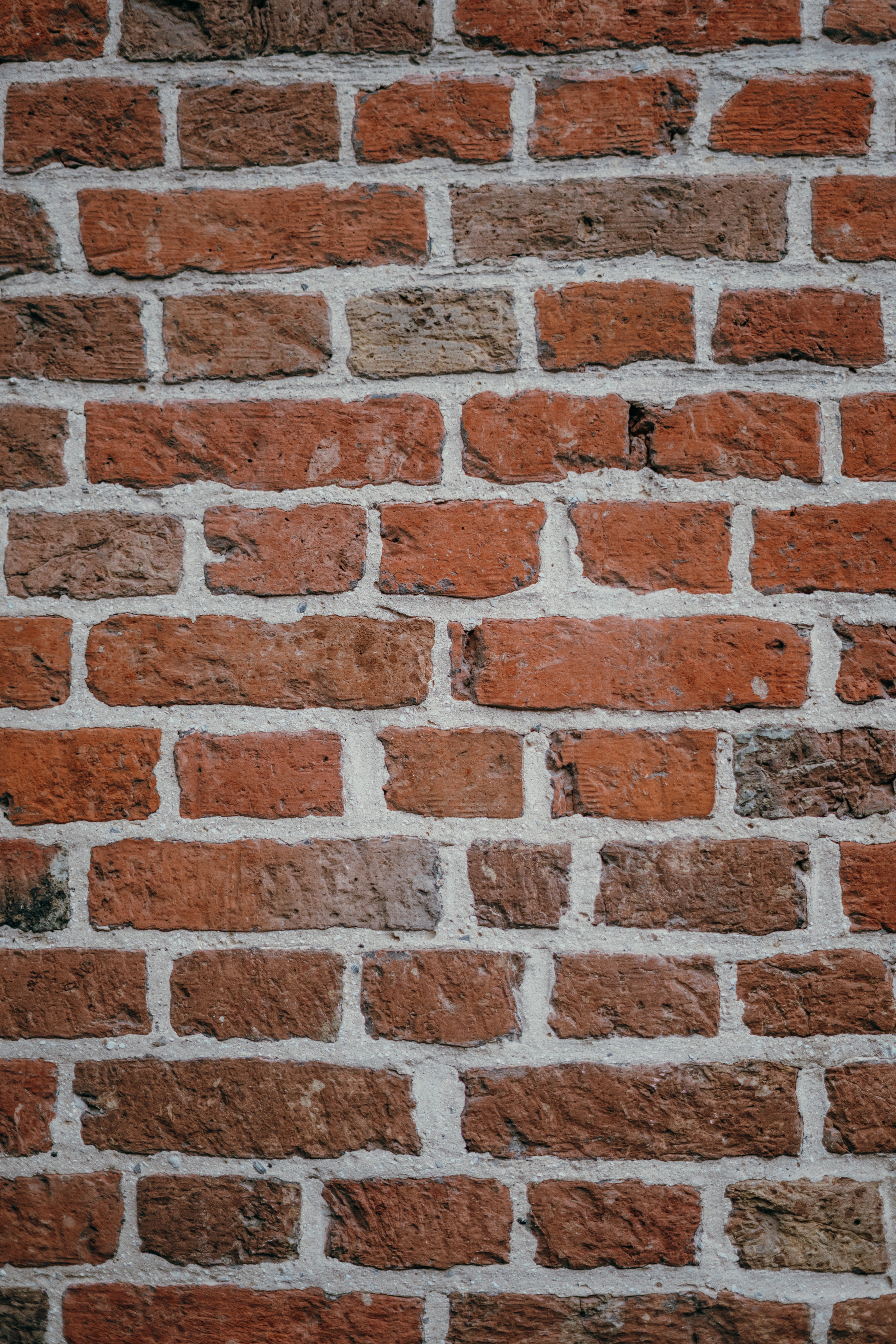 Verweerde rode bakstenen muur met lichte kalkvoegen