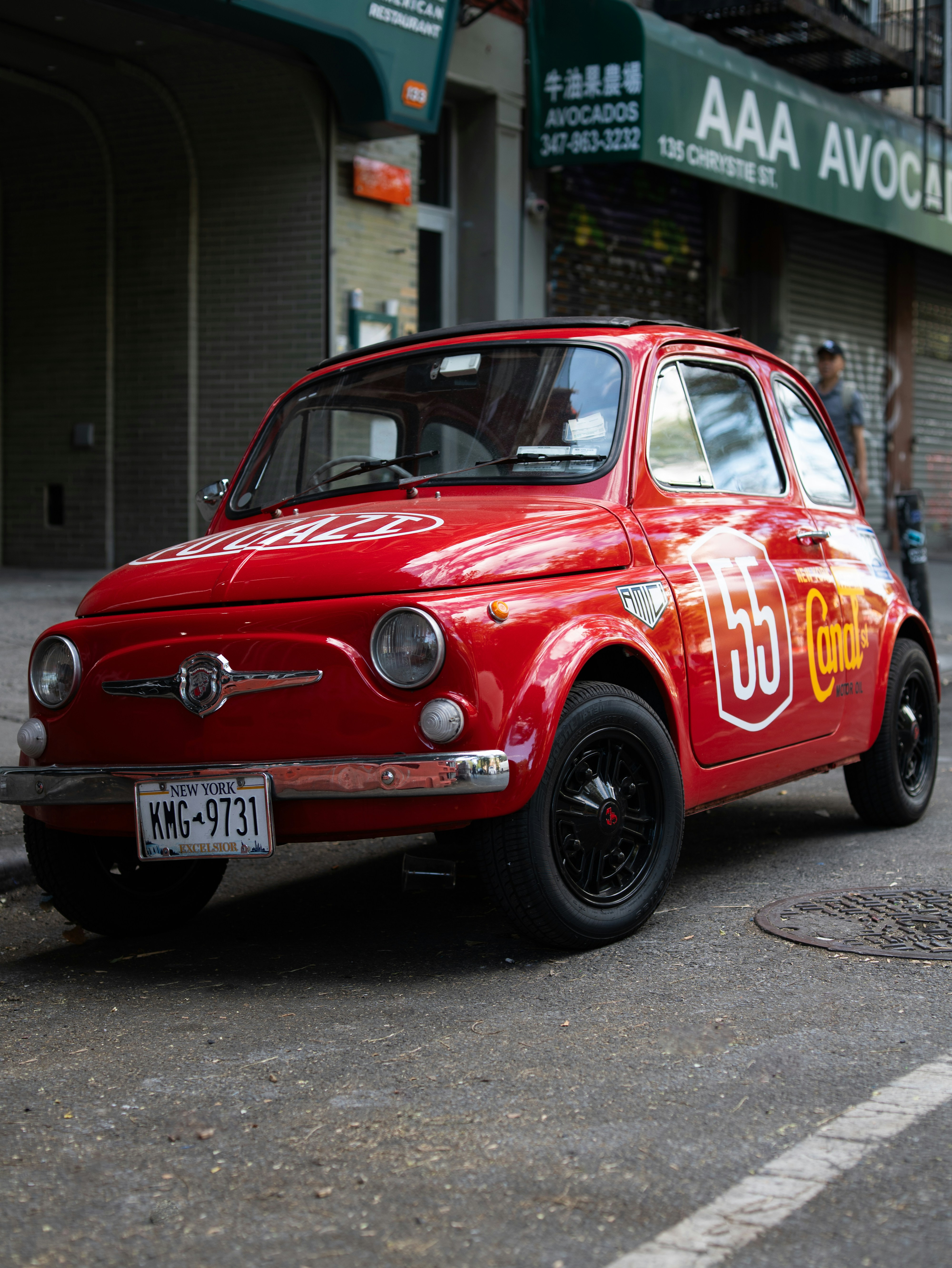 Red vintage fiat 500 with racing decals on side.