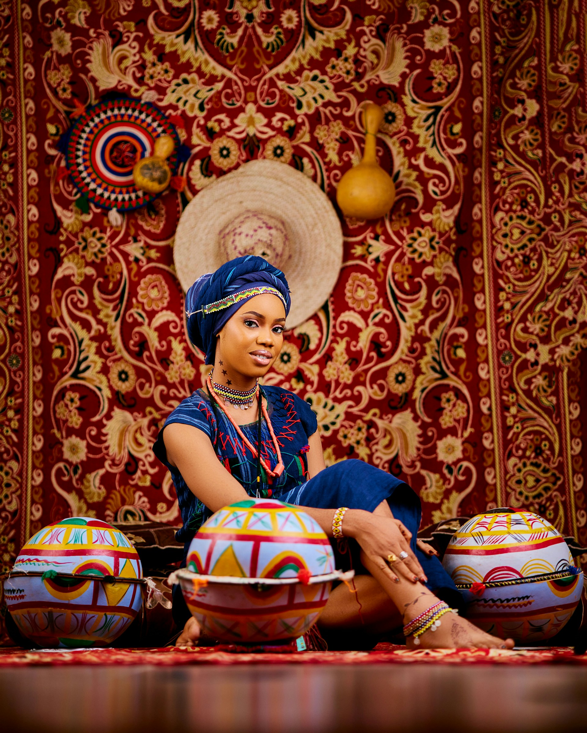 Woman in traditional attire sits amidst ornate decor