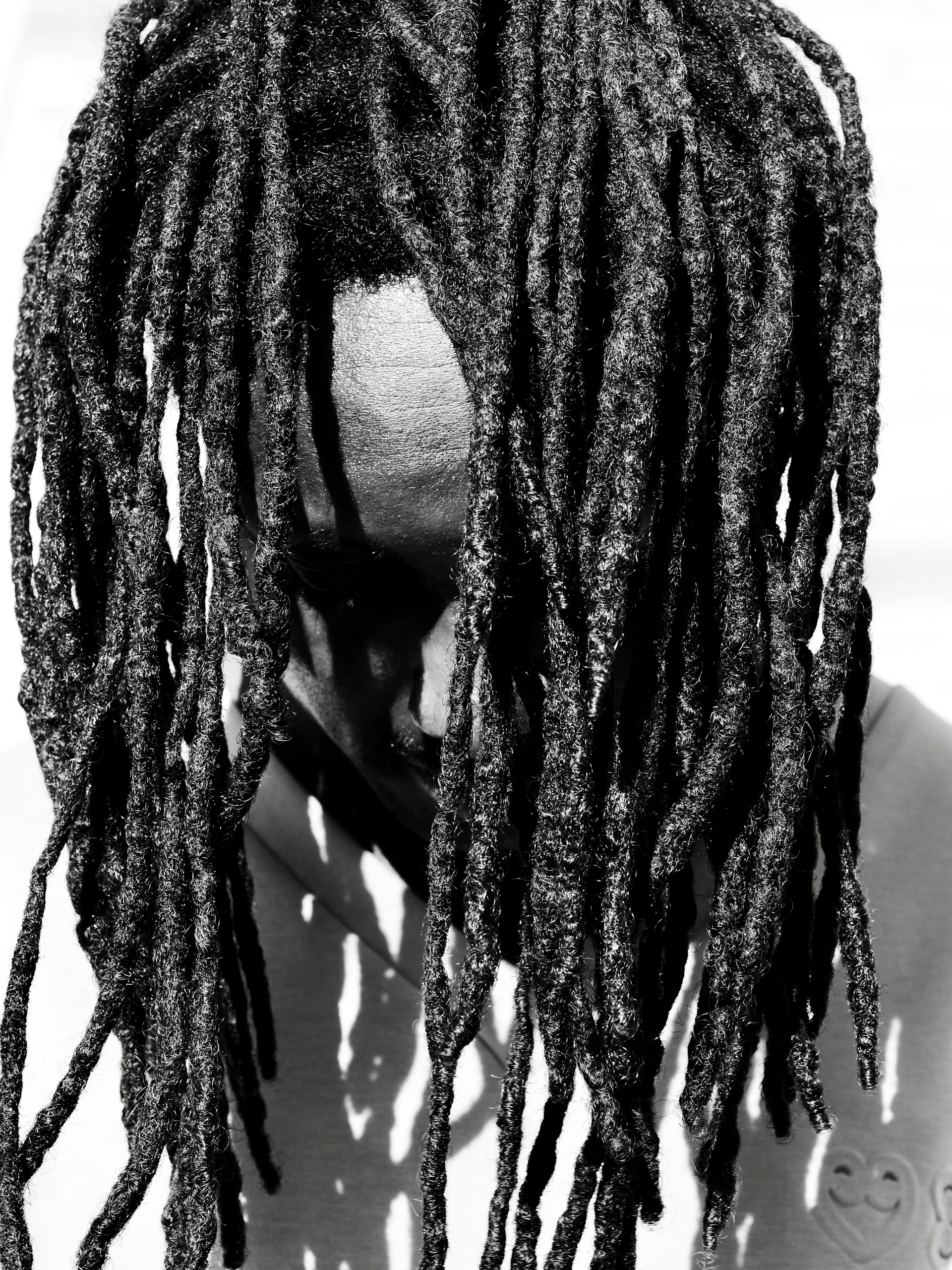 Man with long dreadlocks obscuring face