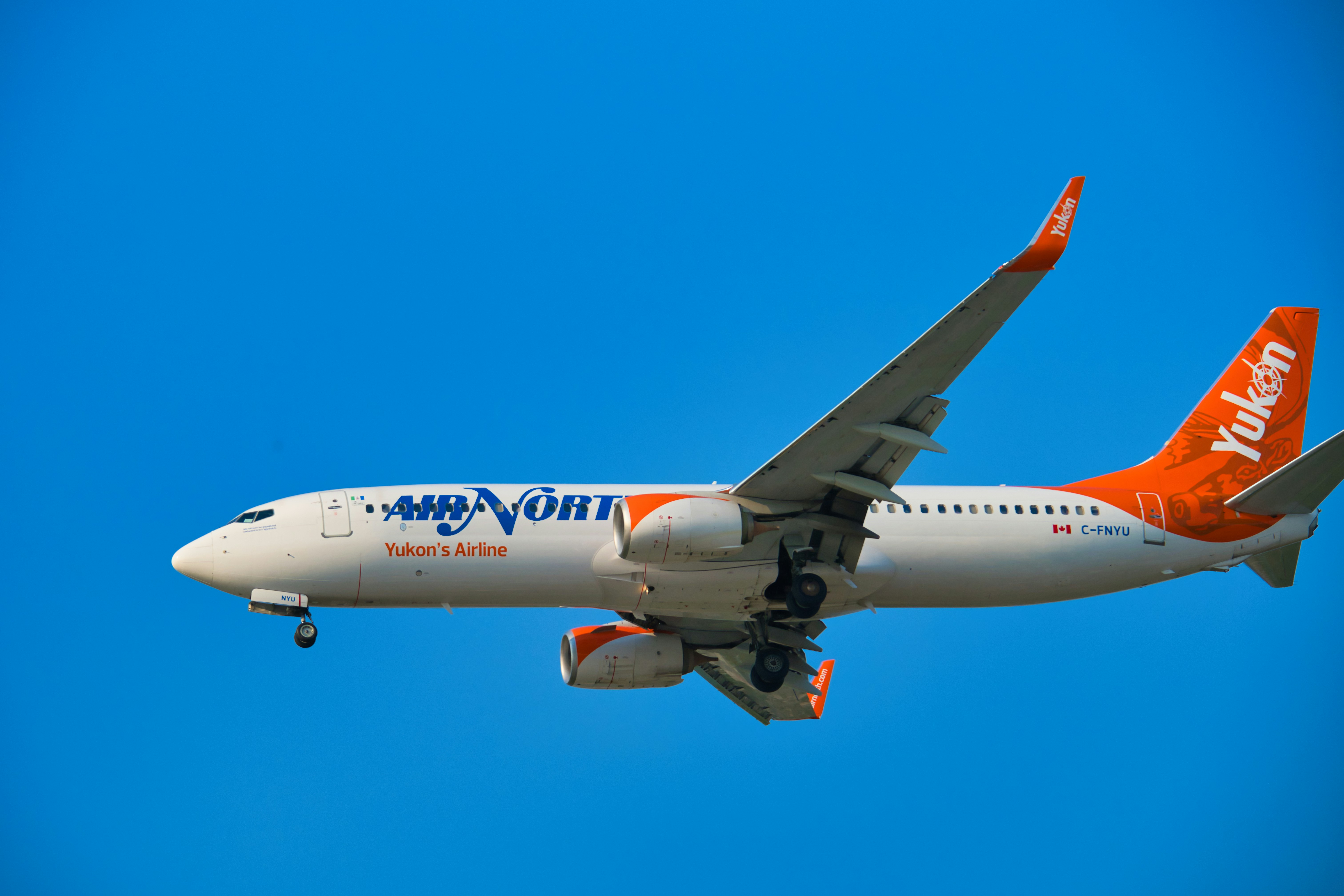 Ein Verkehrsflugzeug, das am strahlend blauen Himmel fliegt.