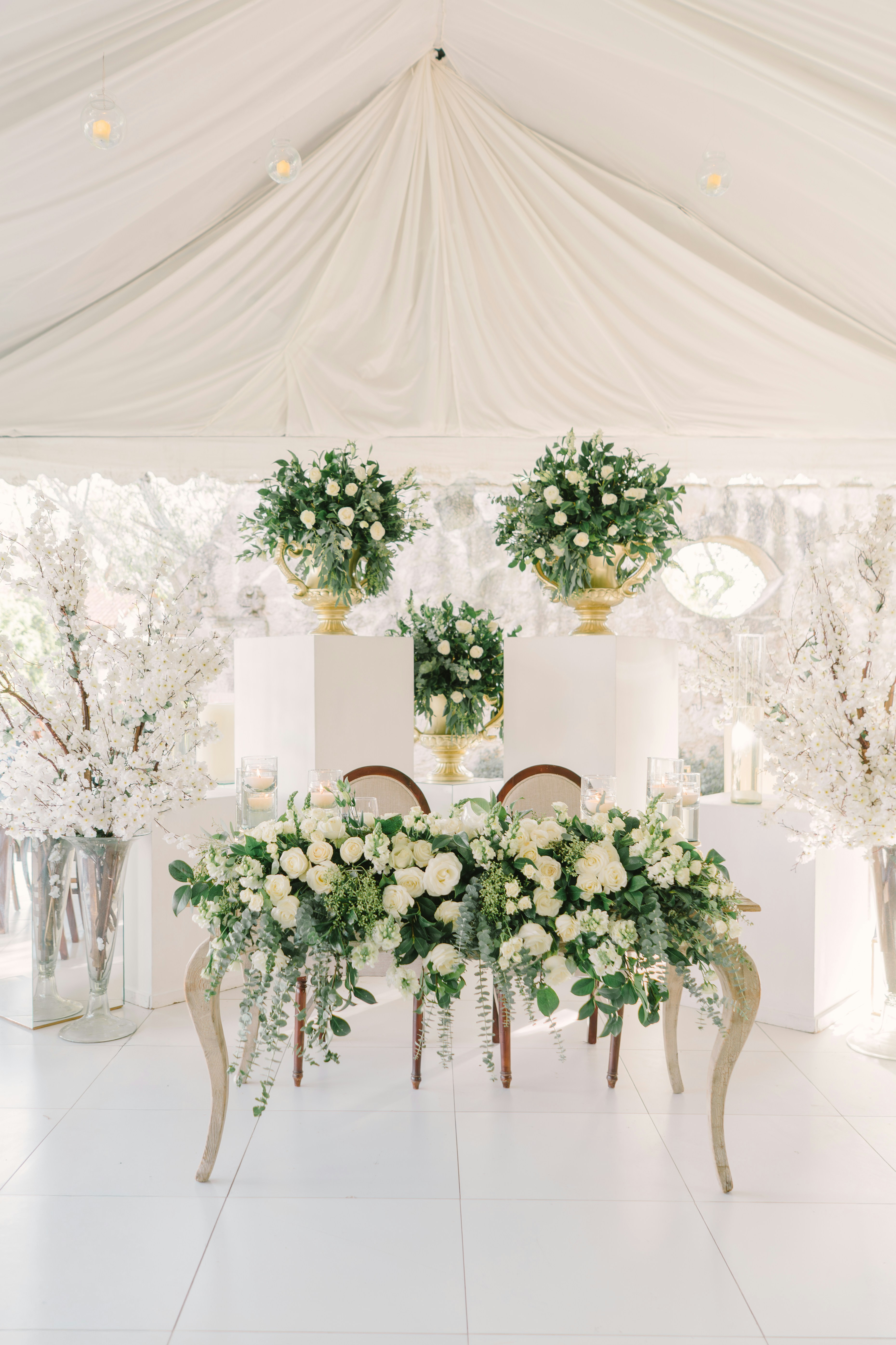 Elegant wedding sweetheart table with abundant white floral arrangements.