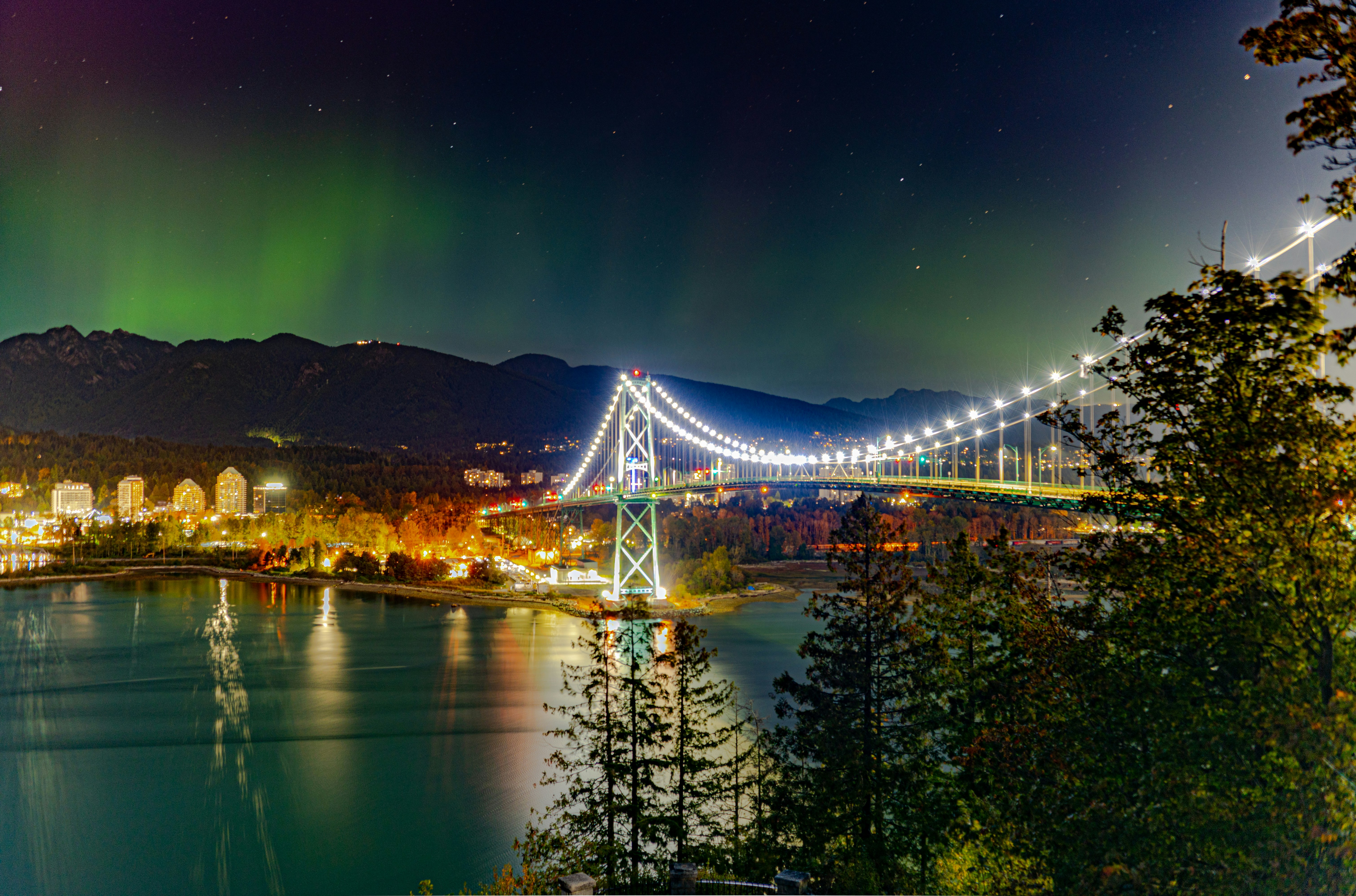 Aurora borealis over illuminated bridge at night